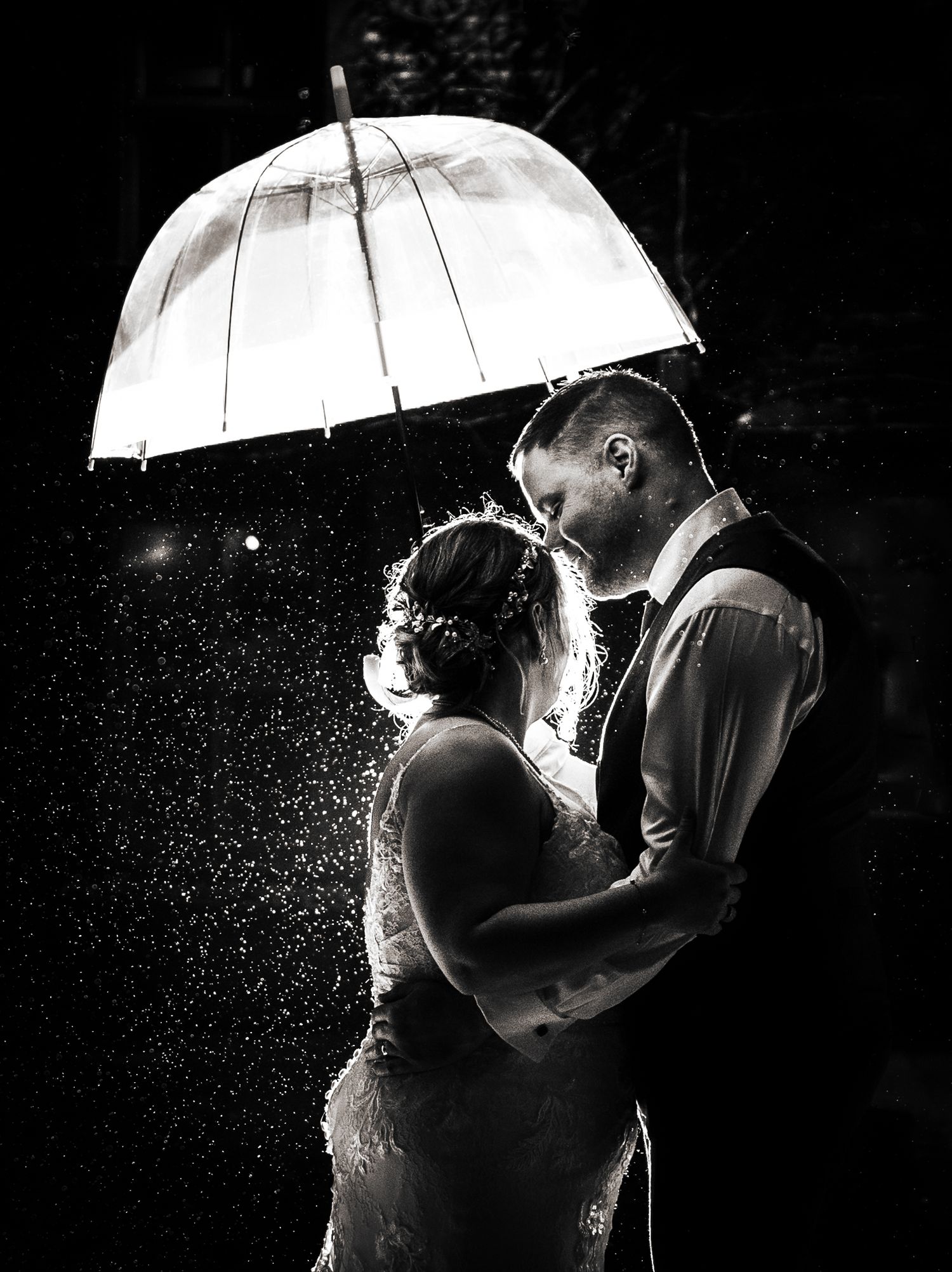 Romantic silhouettes of a couple under white umbrellas in the rain at night, at The Fleece Inn, Halifax.