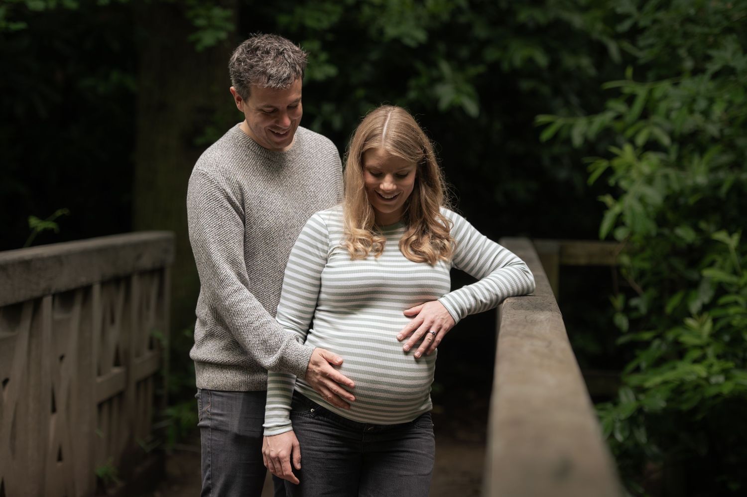 An outdoor maternity photoshoot silhouette against dark trees and foliage in Leeds.