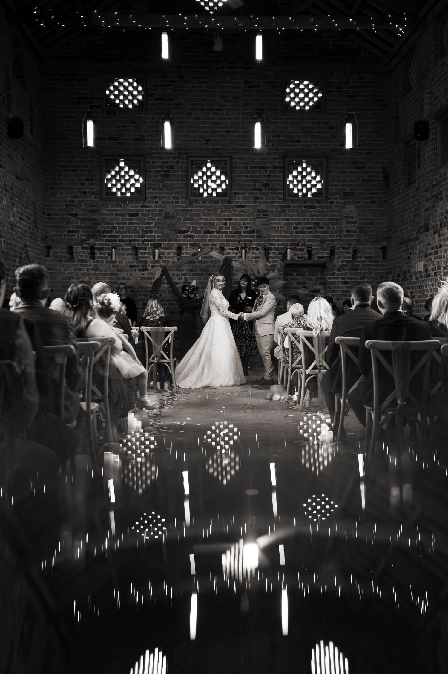 Moody black and white shot of wedding reception with geometric lighting patterns, at Lodge Farm Weddings, Yorkshire.