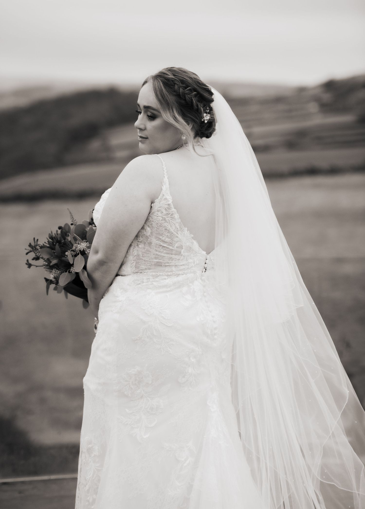 Wedding dress details showing lace and veil against a scenic outdoor backdrop, at The Fleece Inn, Halifax.