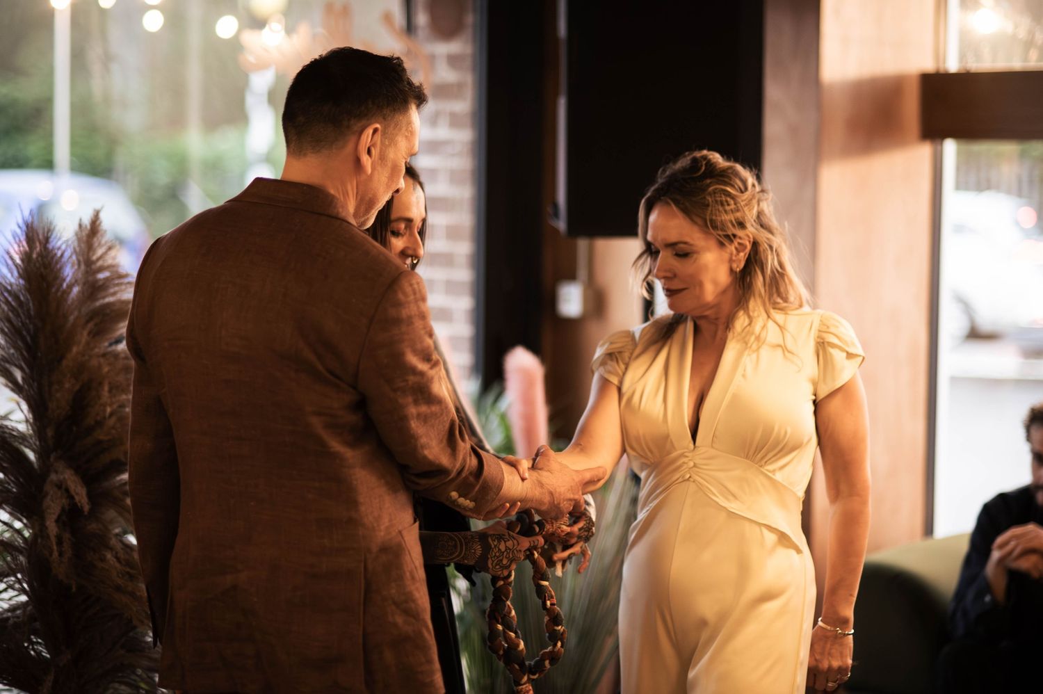 Couple exchanging vows during an intimate indoor wedding ceremony with warm ambient lighting.