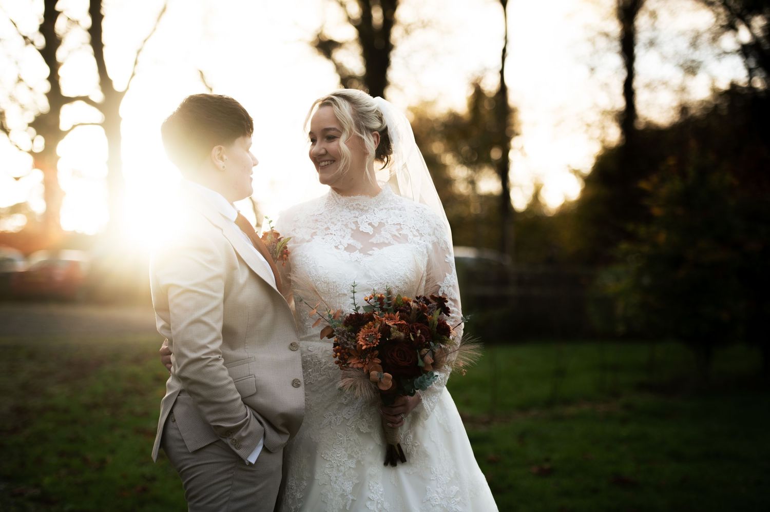 Romantic wedding couple embracing in golden sunset light with trees in background, at Lodge Farm Weddings, Yorkshire.