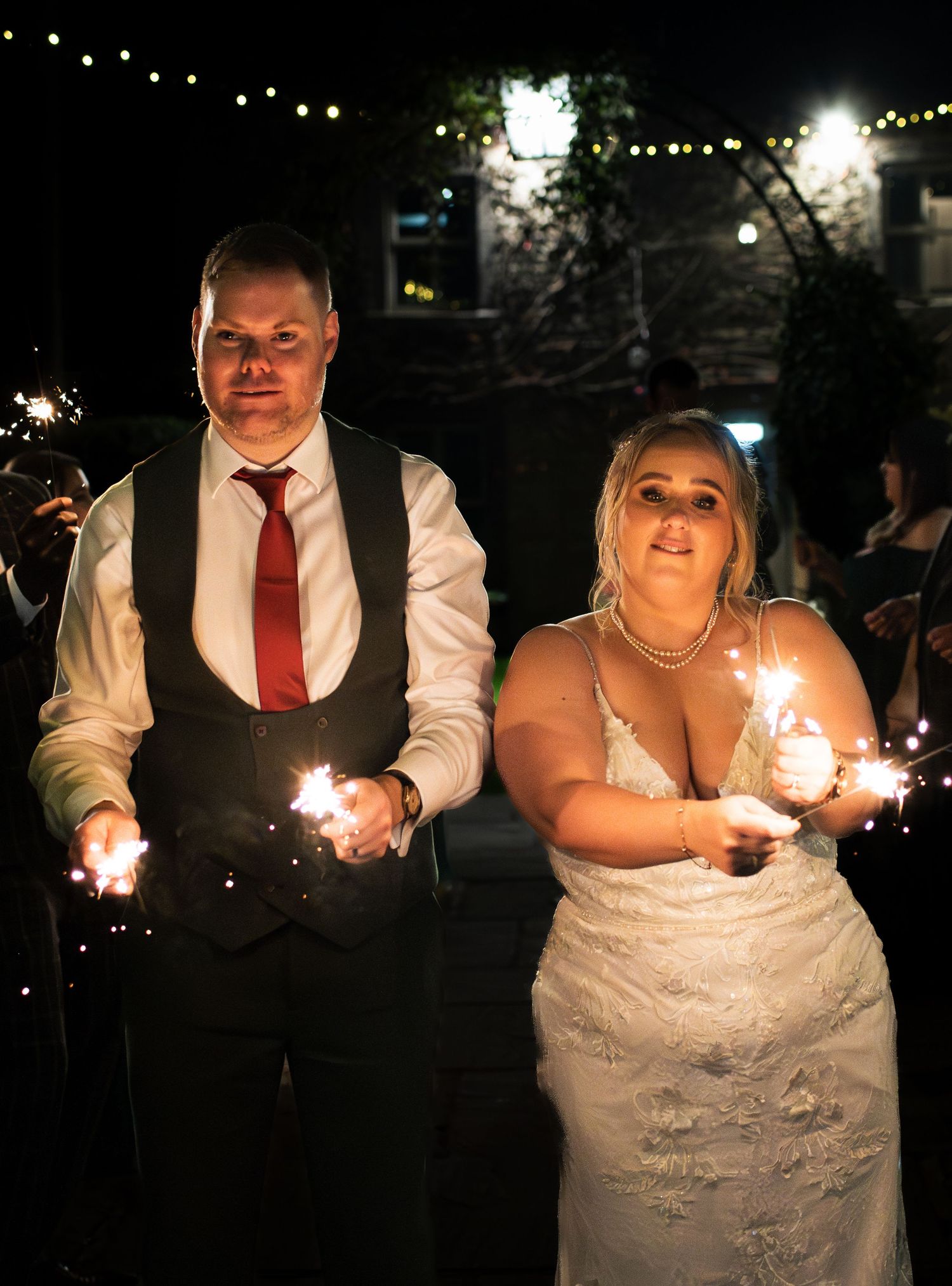 Nighttime wedding celebration with sparklers and string lights creating a festive atmosphere, at The Fleece Inn, Halifax.