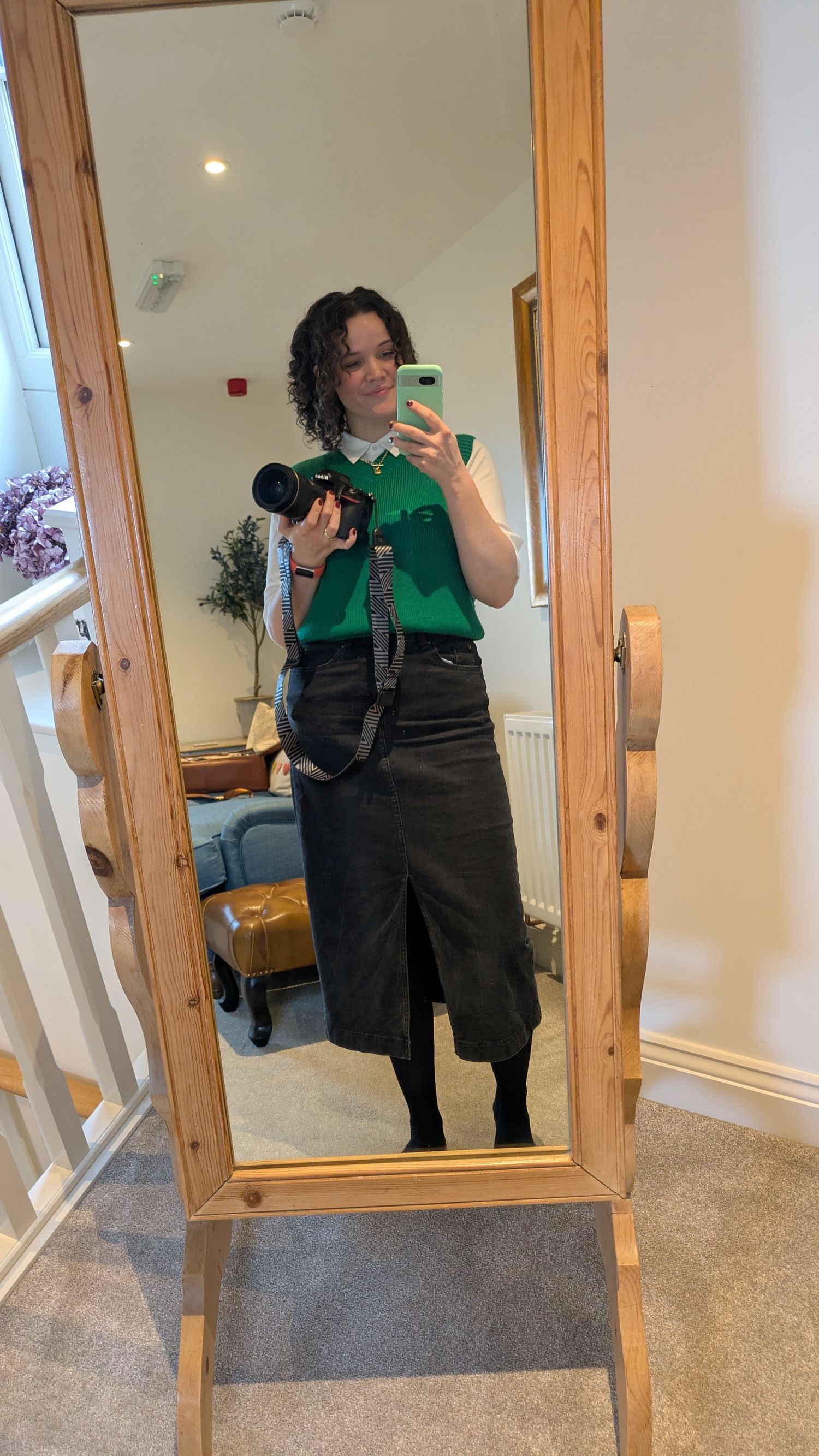 A photographer taking mirror selfies with a camera in a room with wooden-framed mirrors at a wedding in Yorkshire.