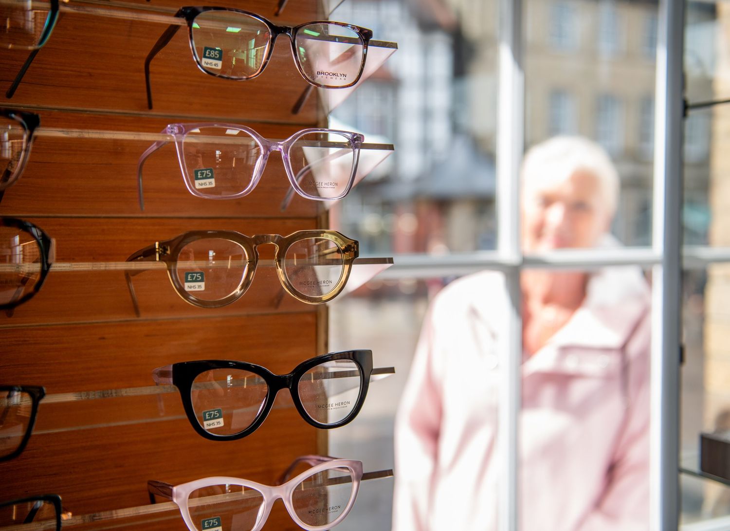 Display of eyeglass frames mounted on wooden wall with blurred background - accompanying business photos in Brigg, North Lincolnshire.