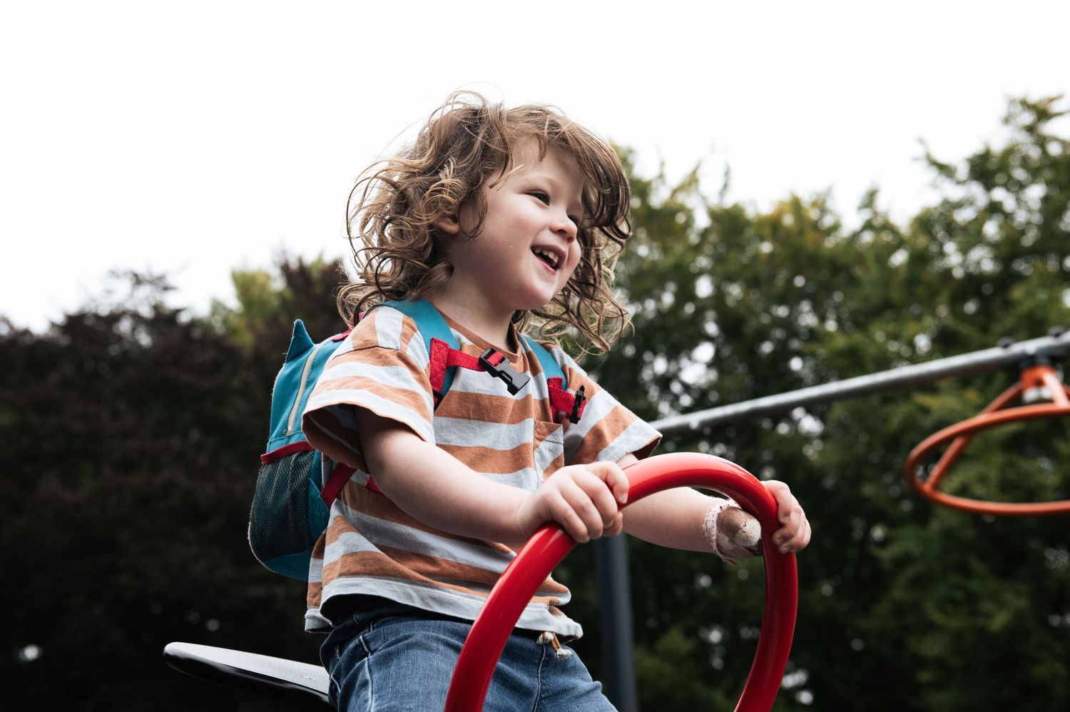 Child playing enthusiastically on a see saw during an outdoor family photoshoot in Leeds.