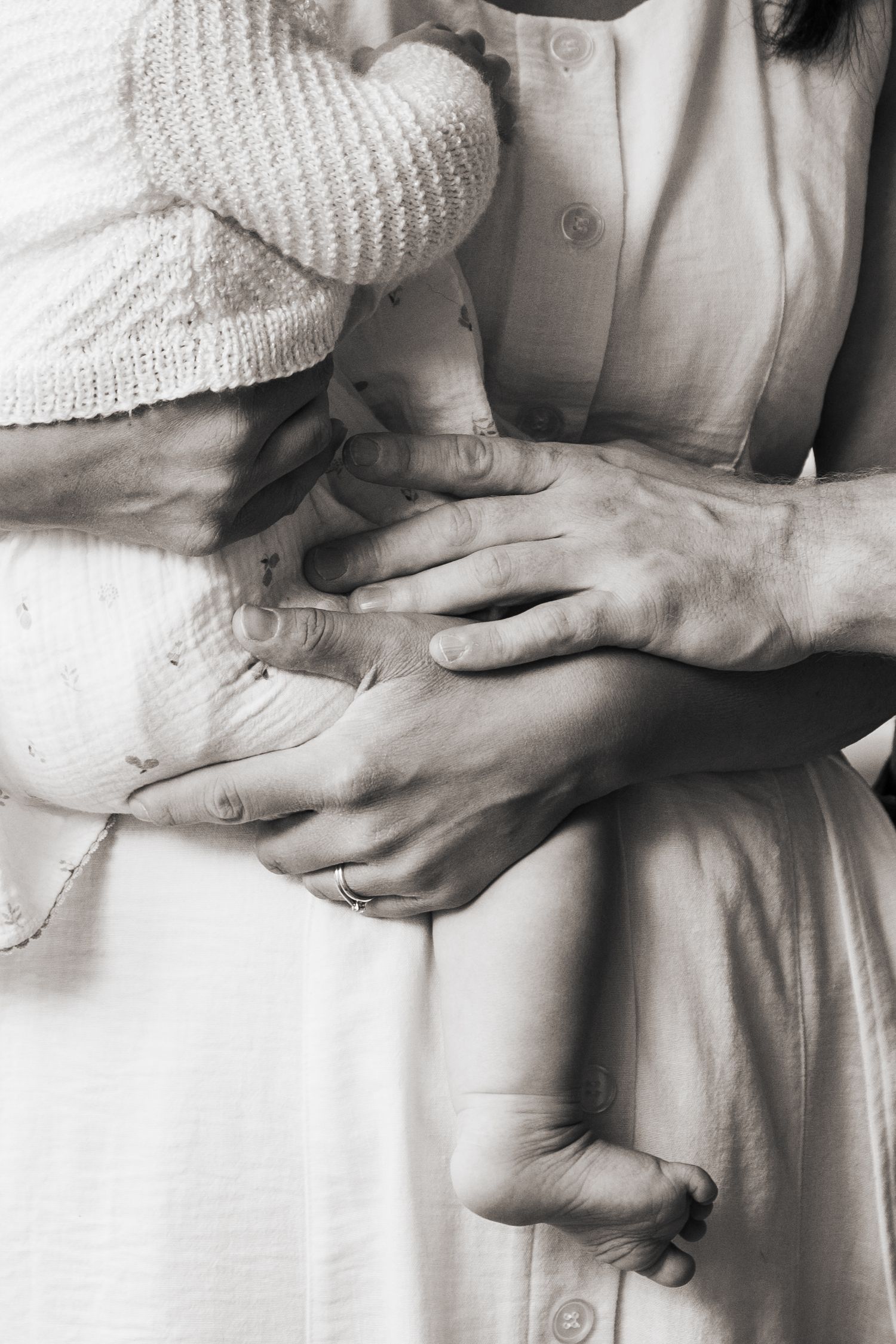 Close-up of hands touching during a family photoshoot.