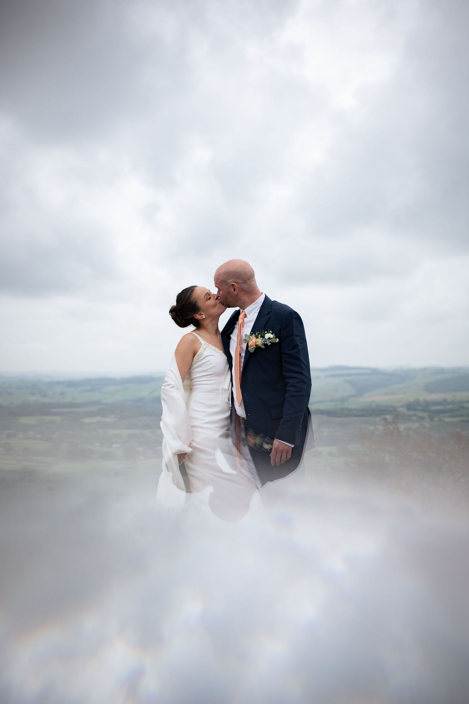 Bride and groom kiss in an artistic prism photo in Buxton.