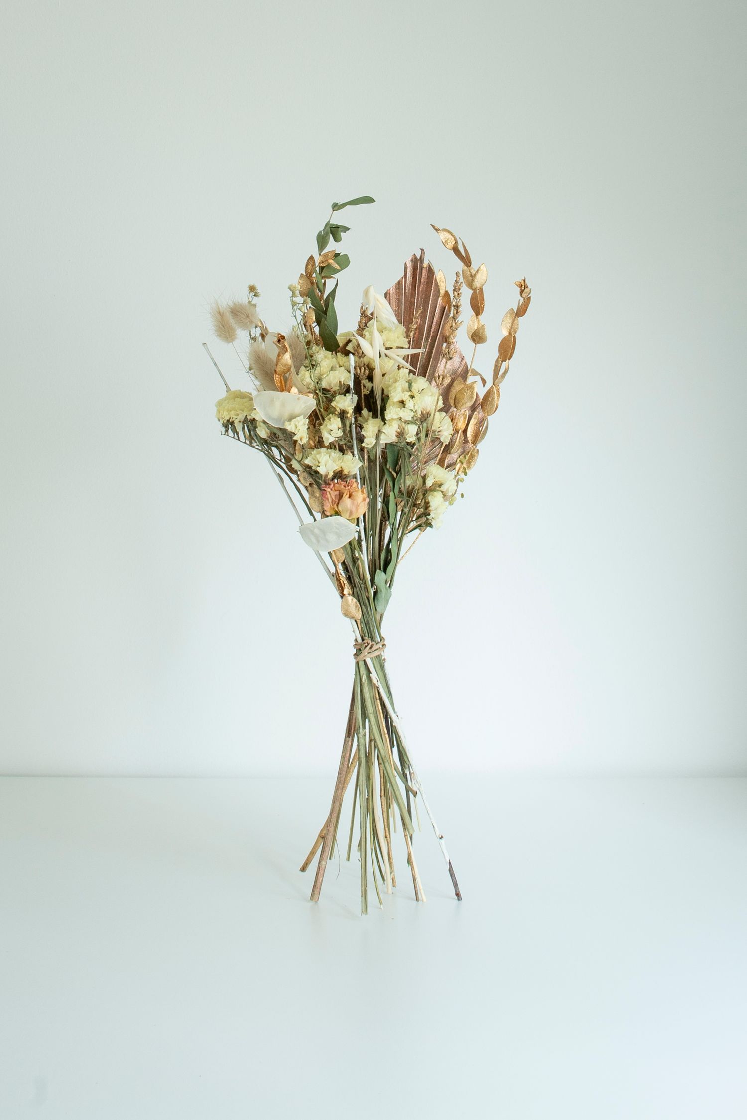 Elegant white and cream dried flower arrangement studio product photo displayed against neutral background, for a Leeds-based florist.