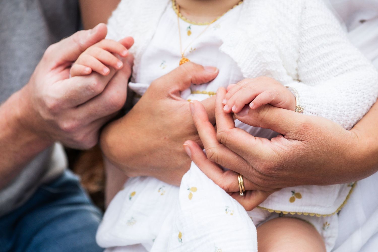 Close-up of hands touching during a family photoshoot.