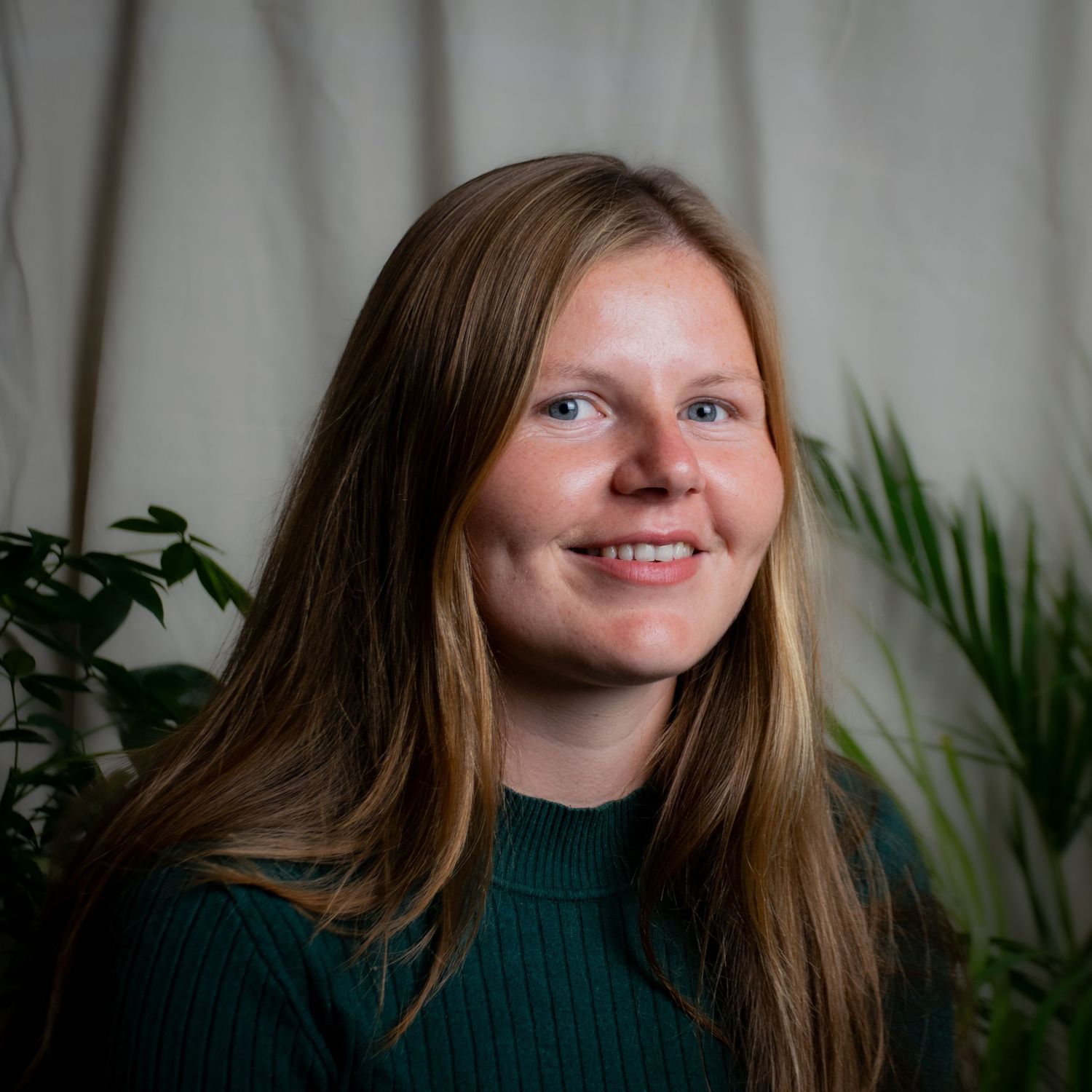 A natural indoor portrait shot against a neutral background with indoor plants, for a Northumbria-based yoga teacher.