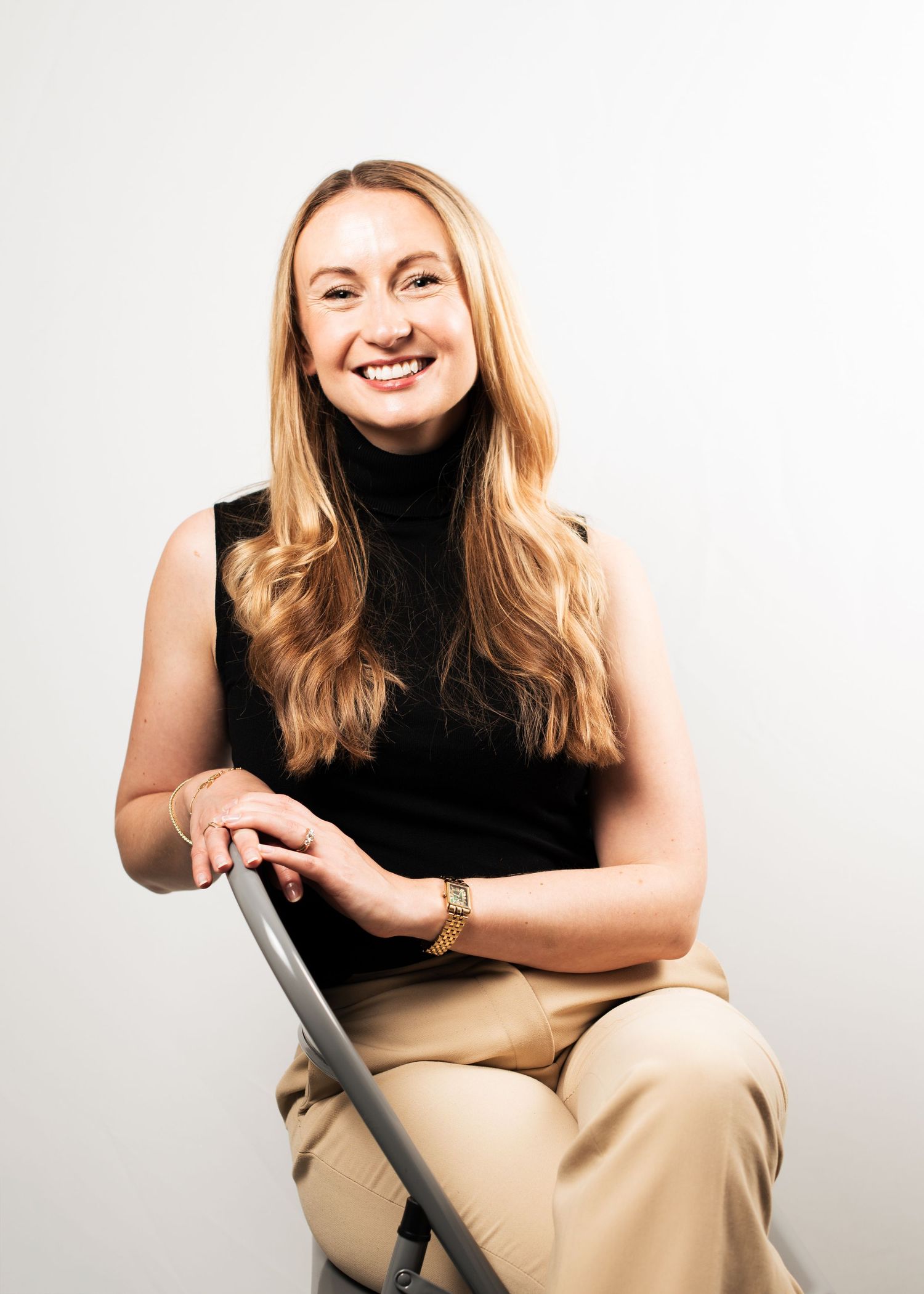 Leeds studio portrait of a woman in black turtleneck and beige pants, for her business headshots.