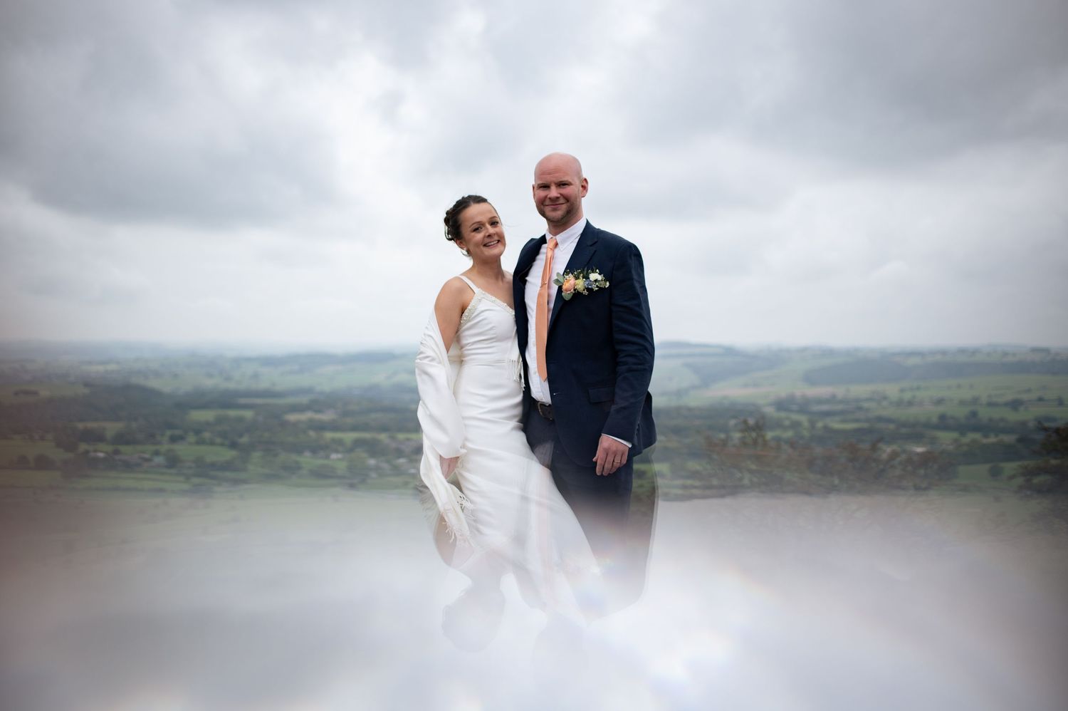 Artistic, naturally lit outdoor wedding photos captured against a moody, cloudy landscape in Buxton.