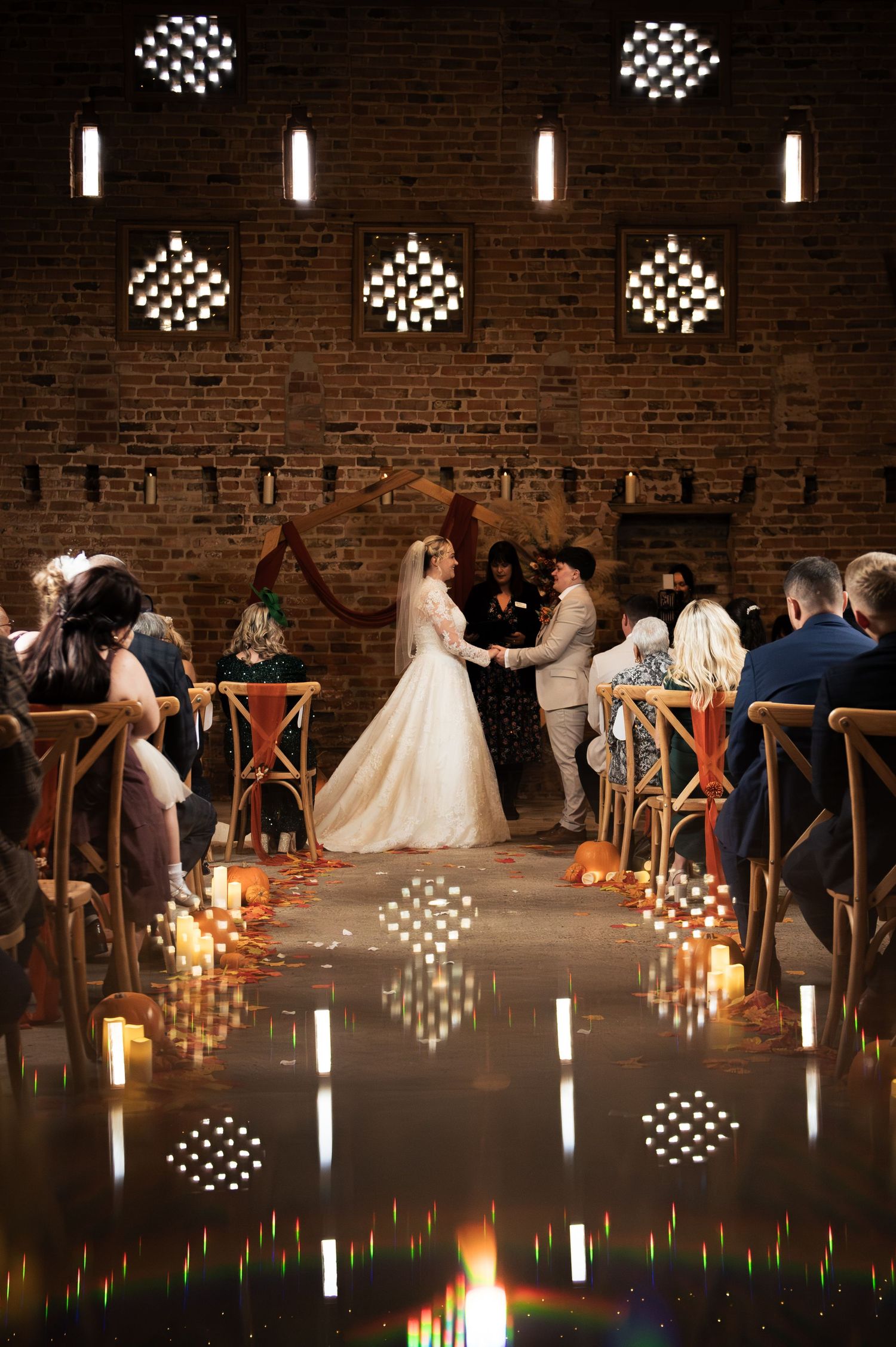 Indoor wedding ceremony with dramatic lighting in Lodge Farm Weddings' beautiful barn conversion in Yorkshire.
