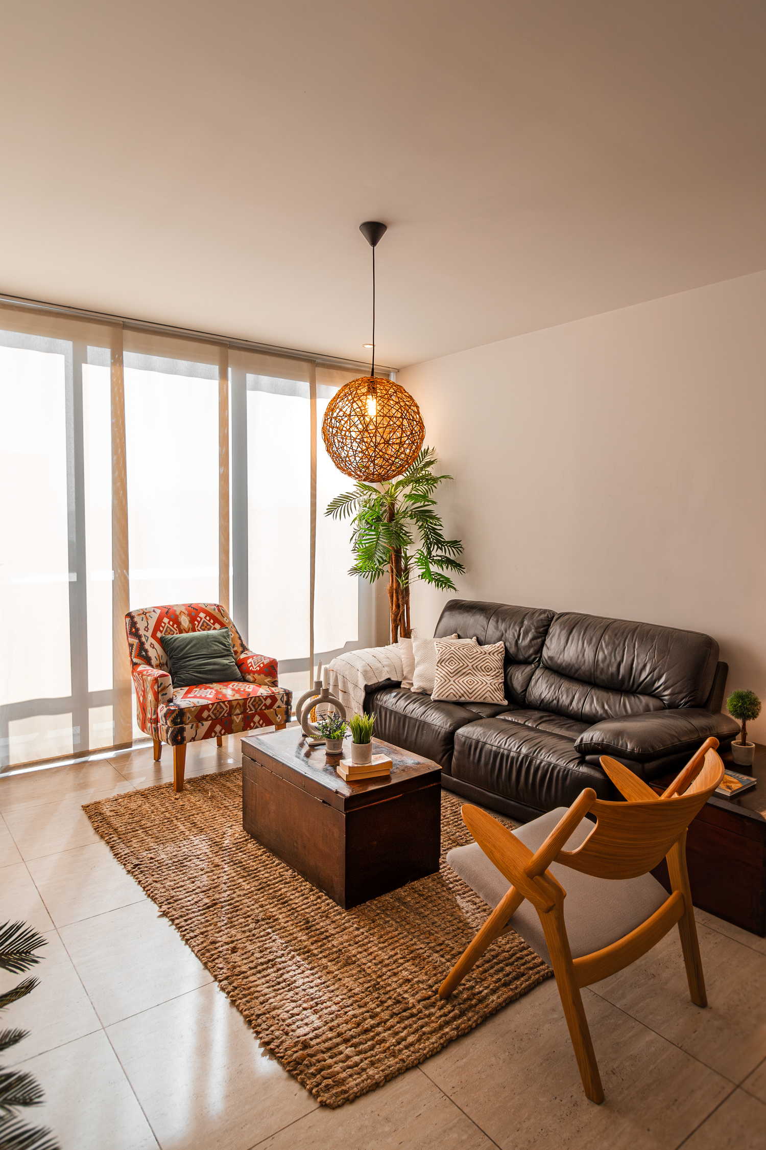 Contemporary living space featuring leather sofa, woven pendant light and natural decor elements.