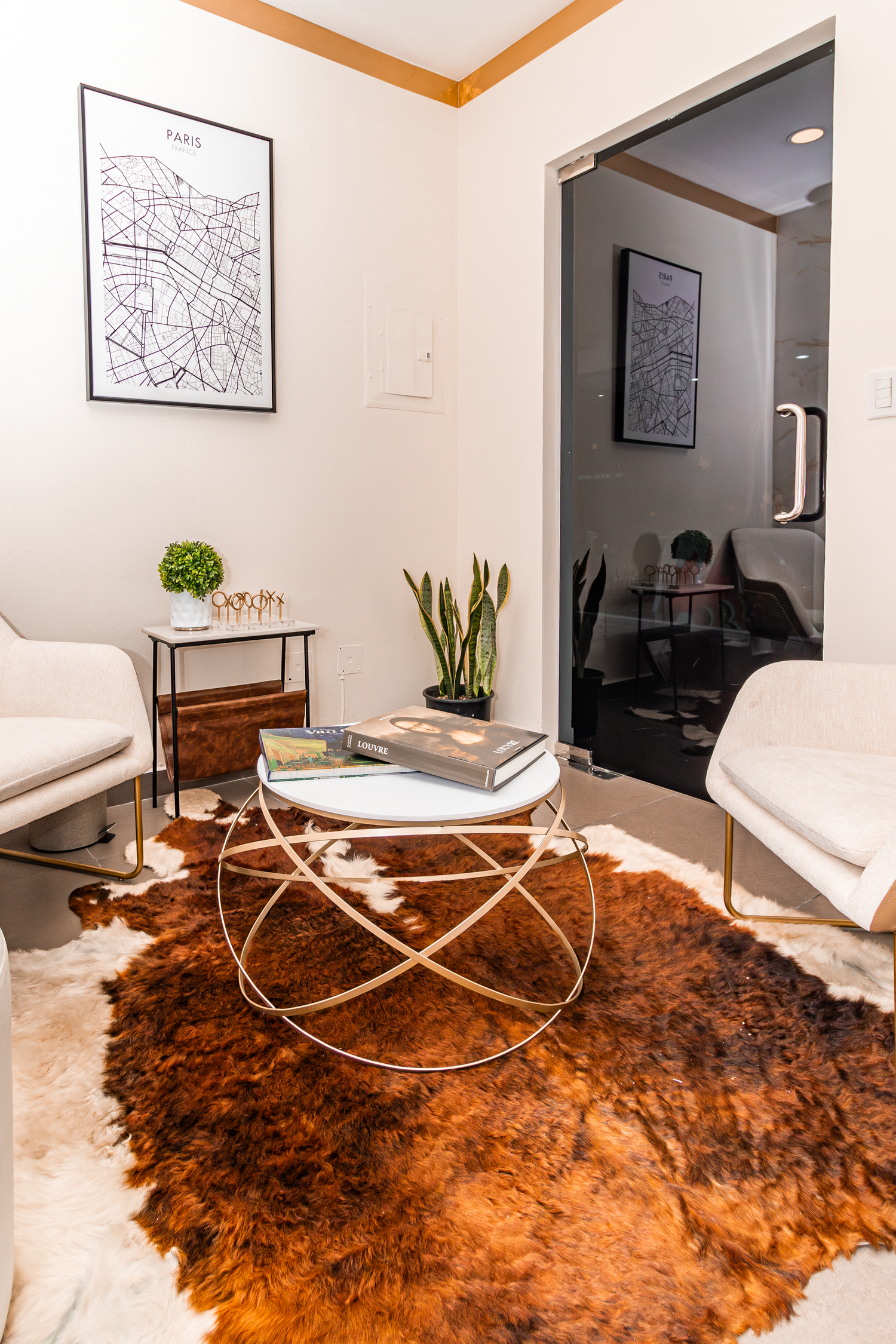 Modern sitting area with geometric coffee table, map artwork and cowhide rug.