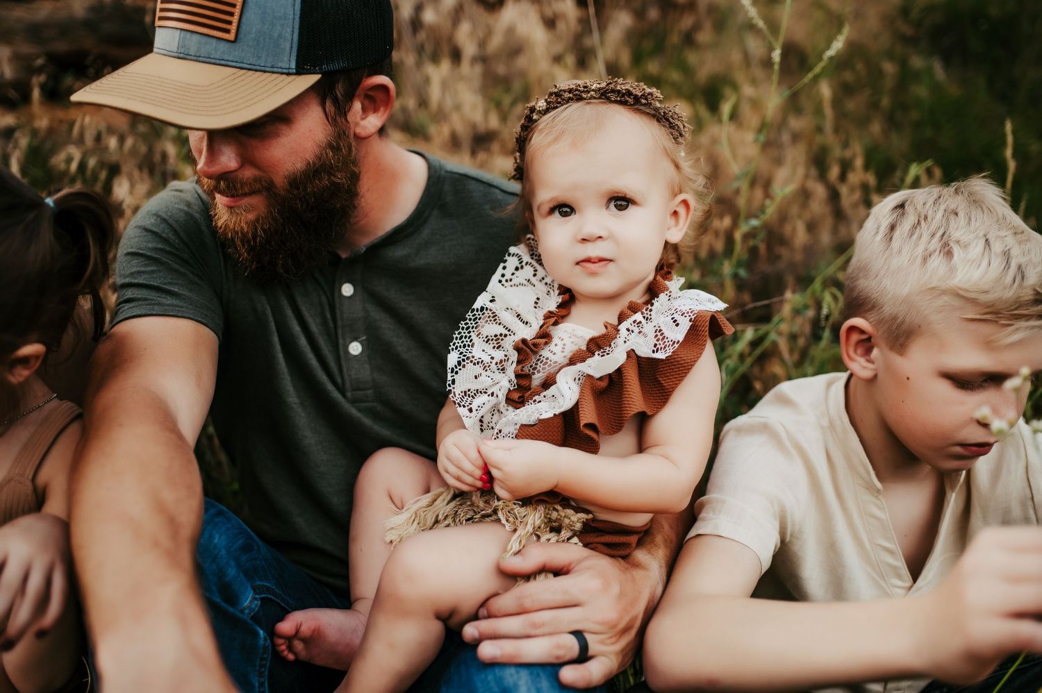 Family sitting together outdoors in casual attire during a summer evening.