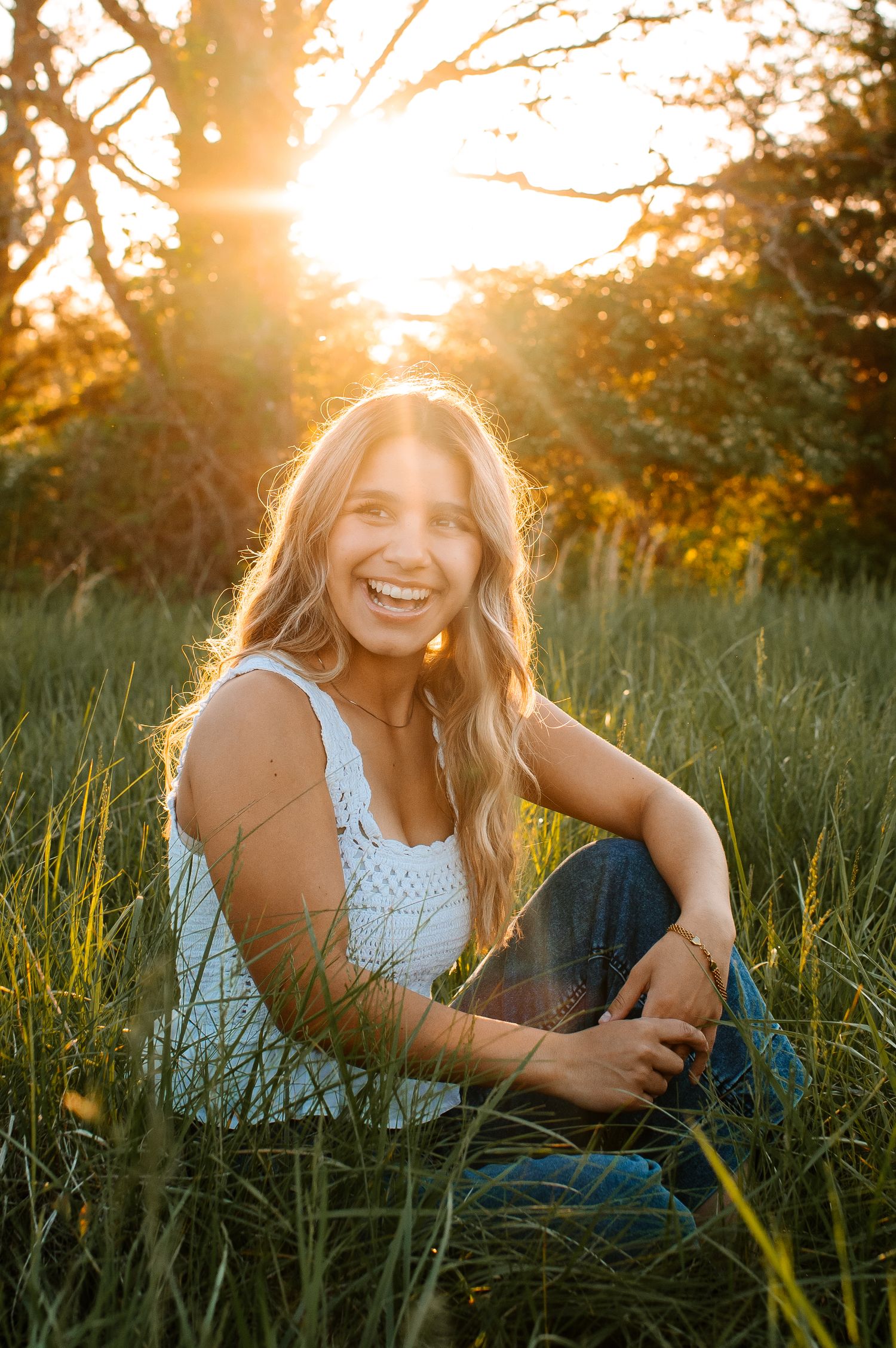 Candid outdoor photoshoot at sunset with sunflare through trees creating magical golden hour lighting.