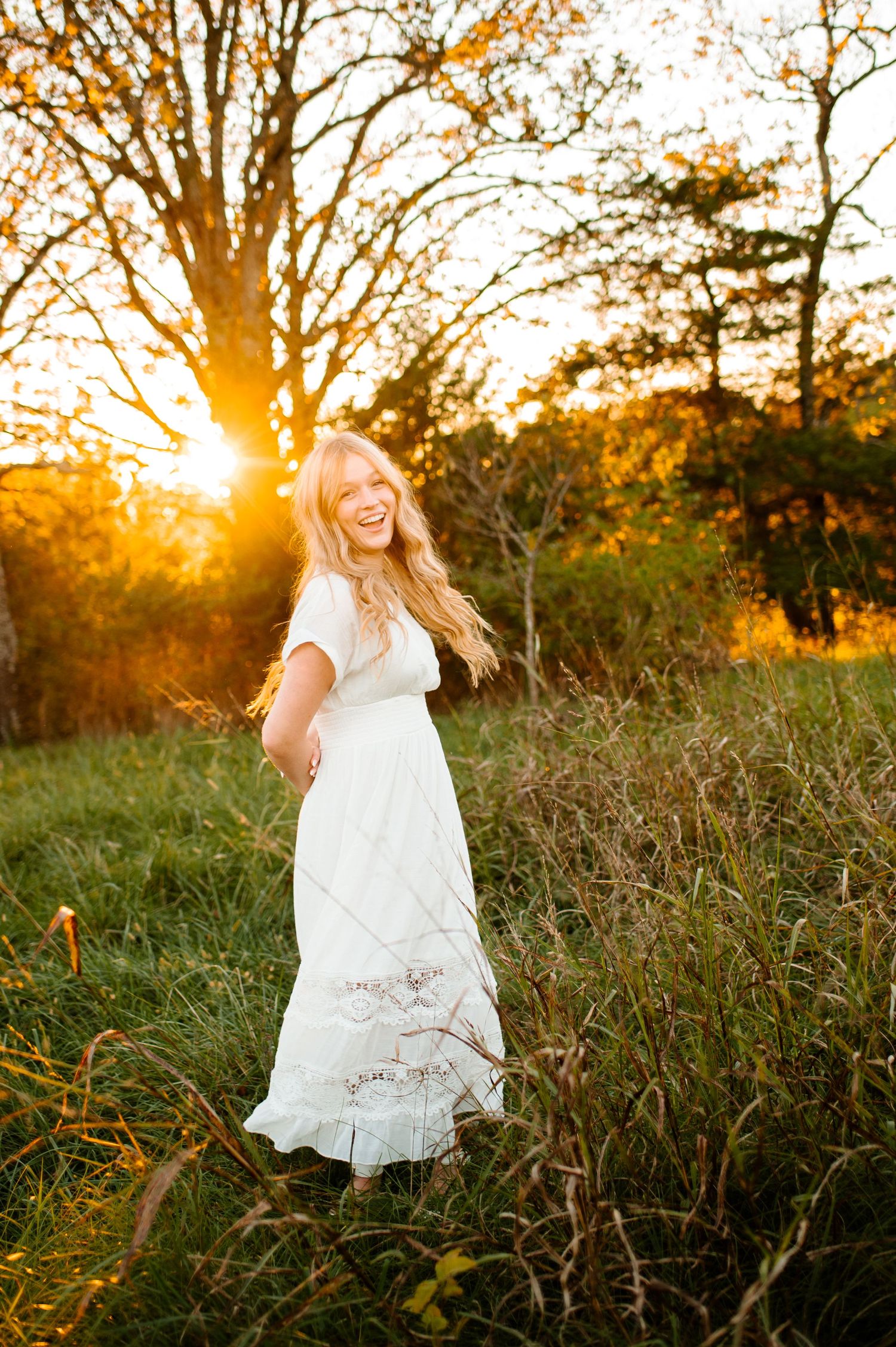 White dress twirling photo against golden sunset in field.