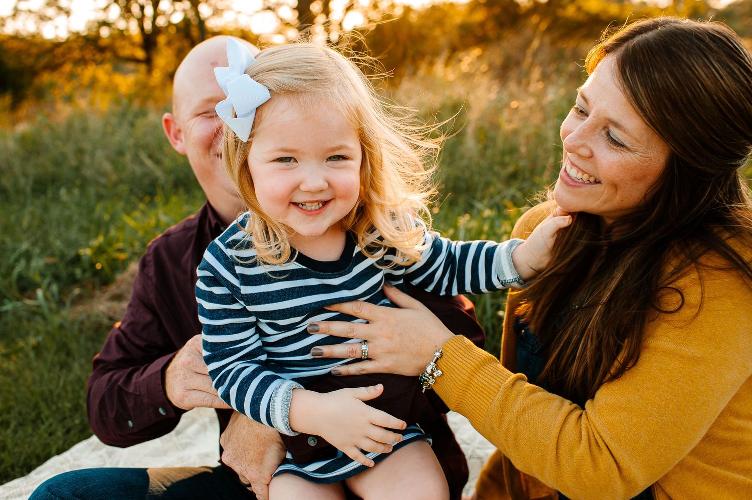 A playful family moment captured during sunset in an outdoor setting.