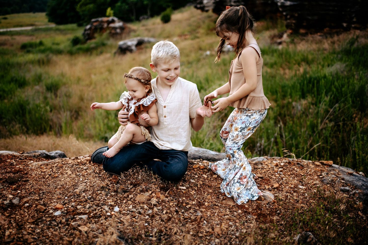 A playful outdoor scene of people sitting on rocky terrain during sunset.