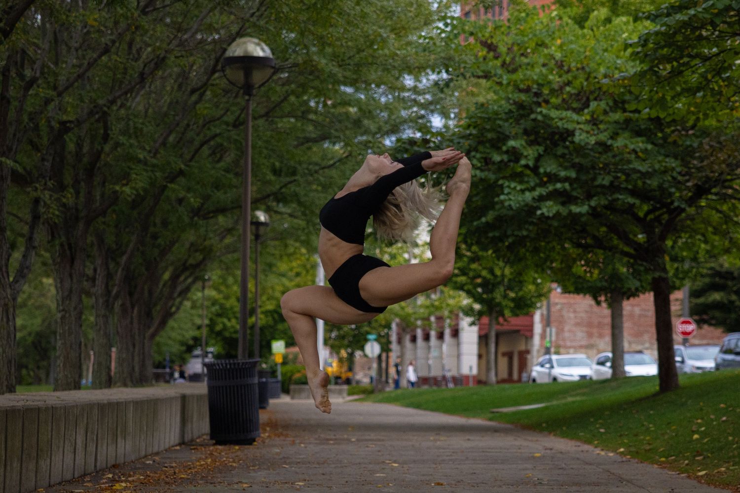 Athletic movements photographed in sequence along tree-lined path.