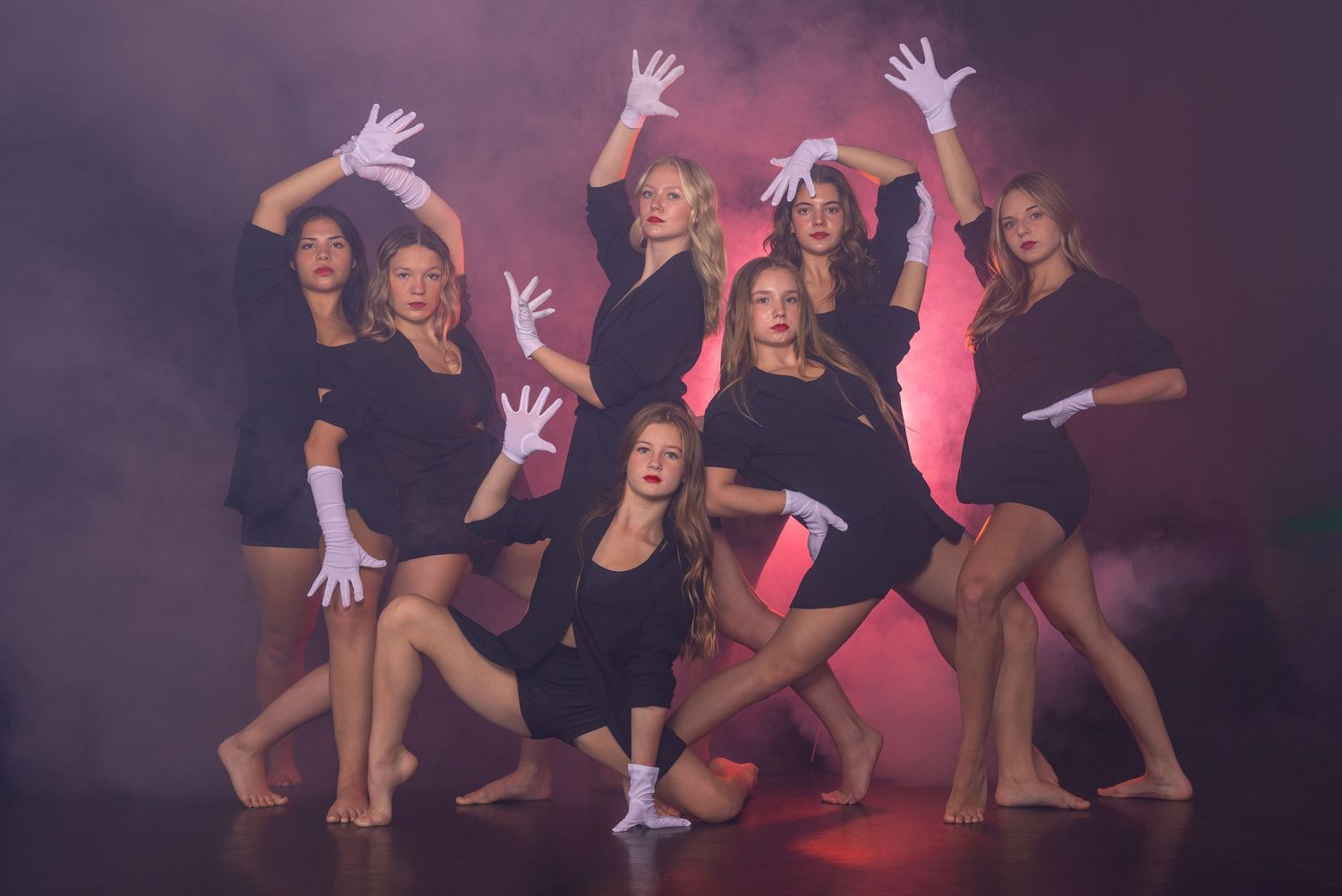 Dancers in black outfits strike dynamic poses against a purple backdrop in a sequential photo series.