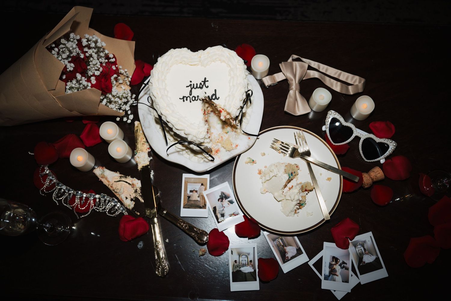 Late night wedding flatlay. Holiday themed flatlay with plates, decorations, and polaroid photos on dark background.