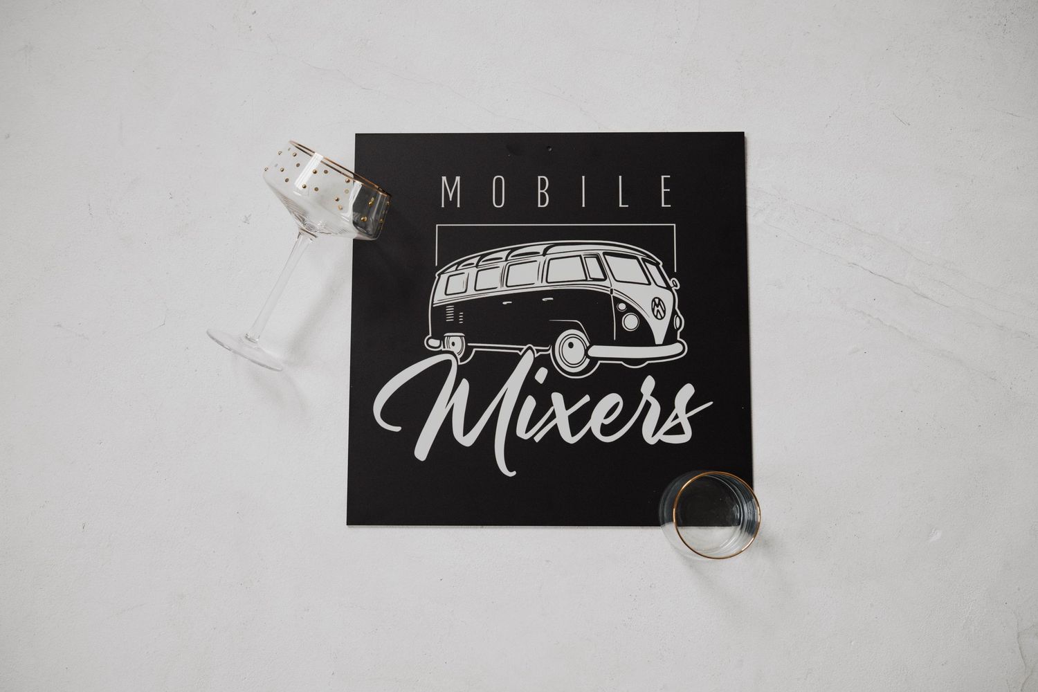 A black and white logo design featuring a vintage car and text reading 'Mobile Mixers' on a dark background.