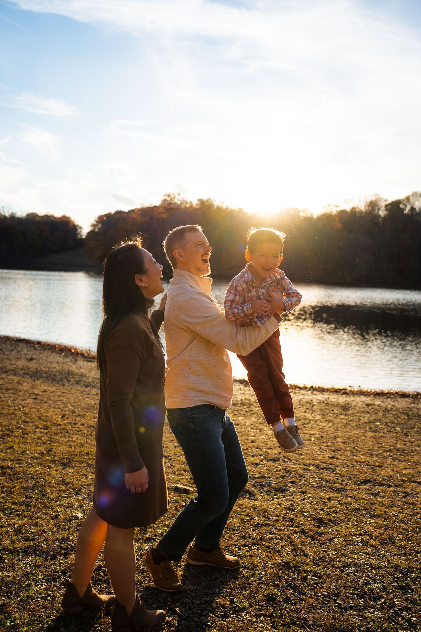 A family enjoying a fun moment together on the shoreline at sunset.