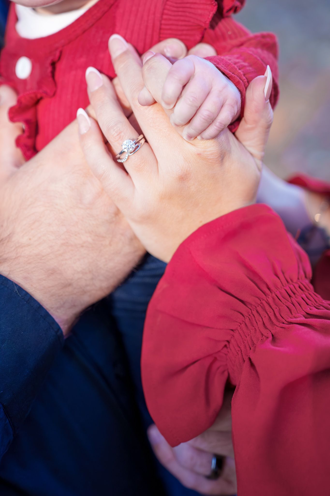 Close-up series of hands with engagement ring showing affectionate moments in red and navy clothing.