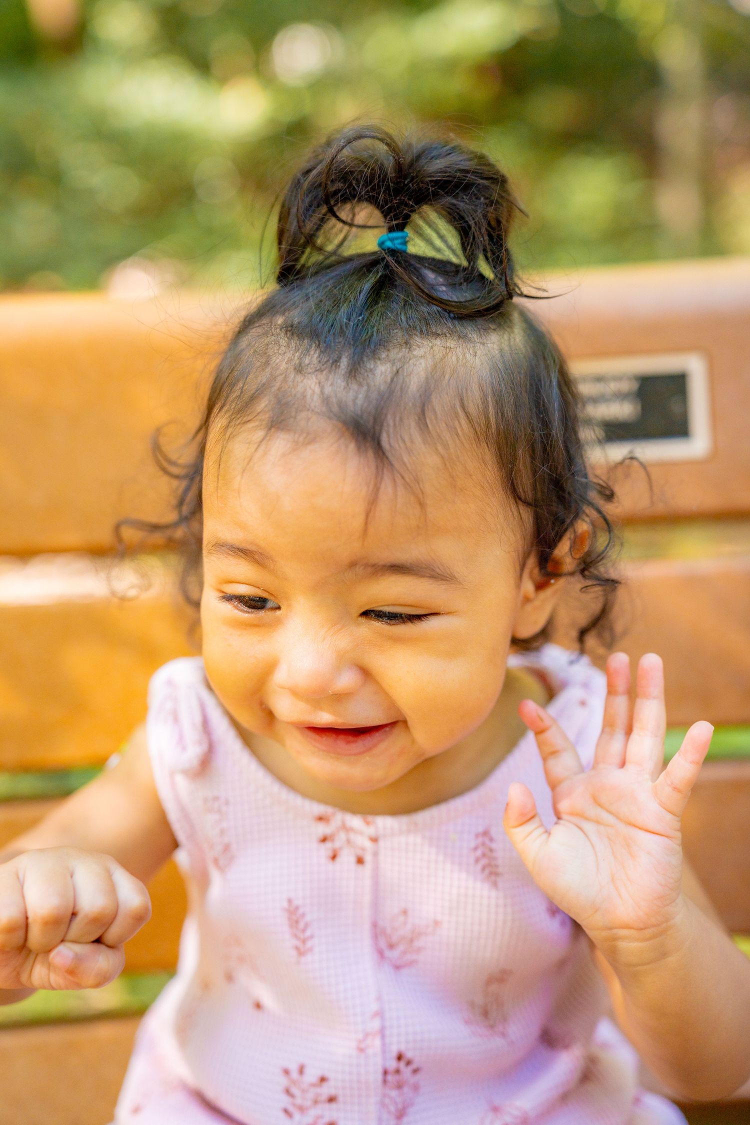 A series of photos showing a baby wearing a pink dress expressing joyful emotions and gestures.