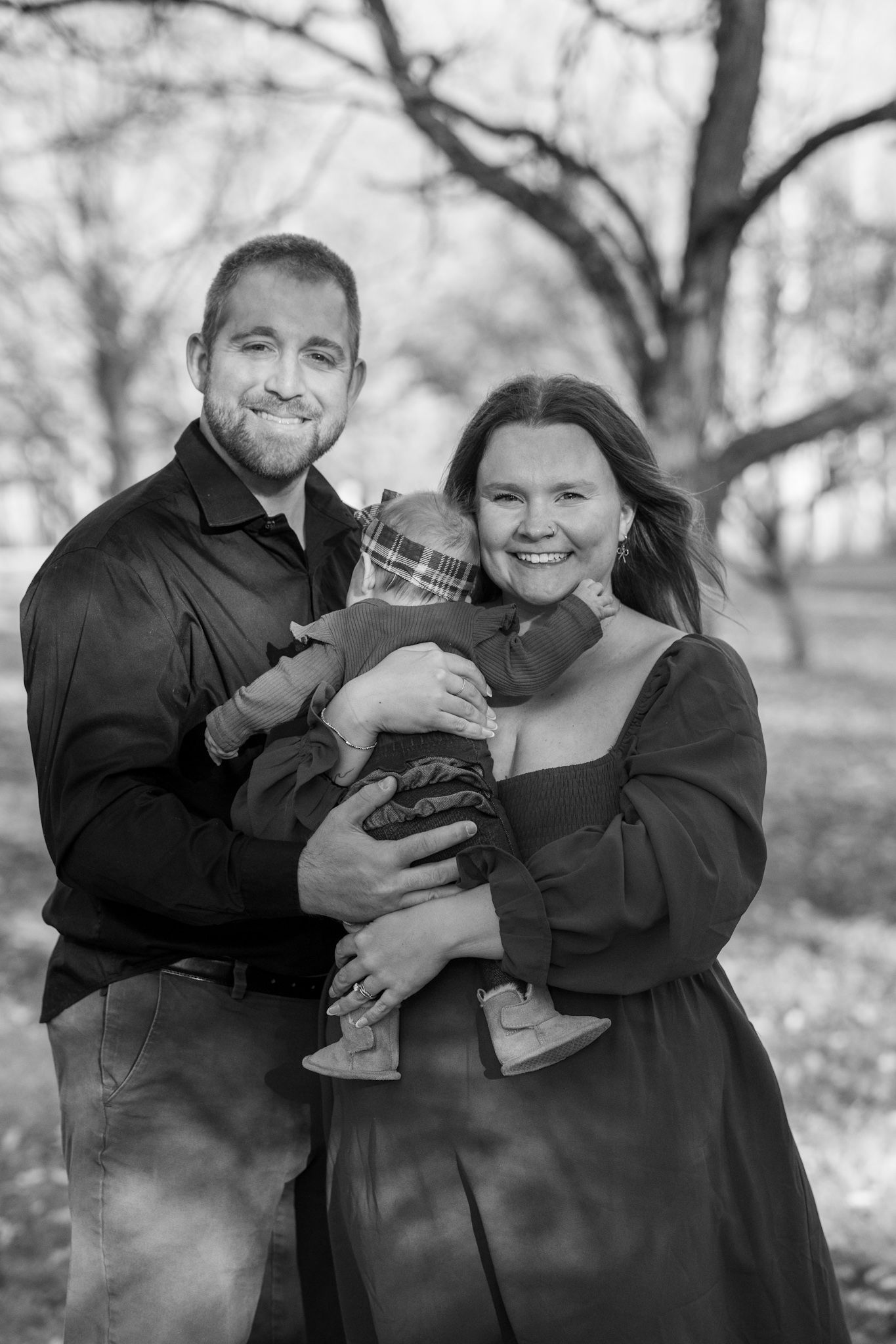 Black and white photo series showing a couple embracing and laughing together in a park setting.