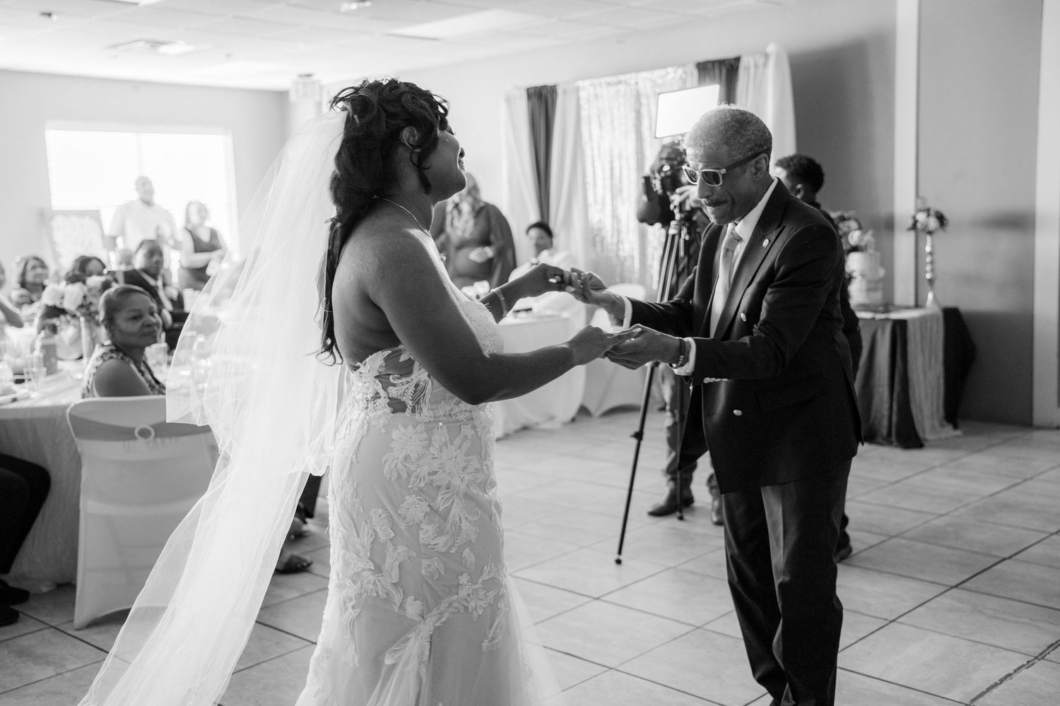A tender moment at a wedding ceremony as a couple shares their first dance together in a bright sunlit room.