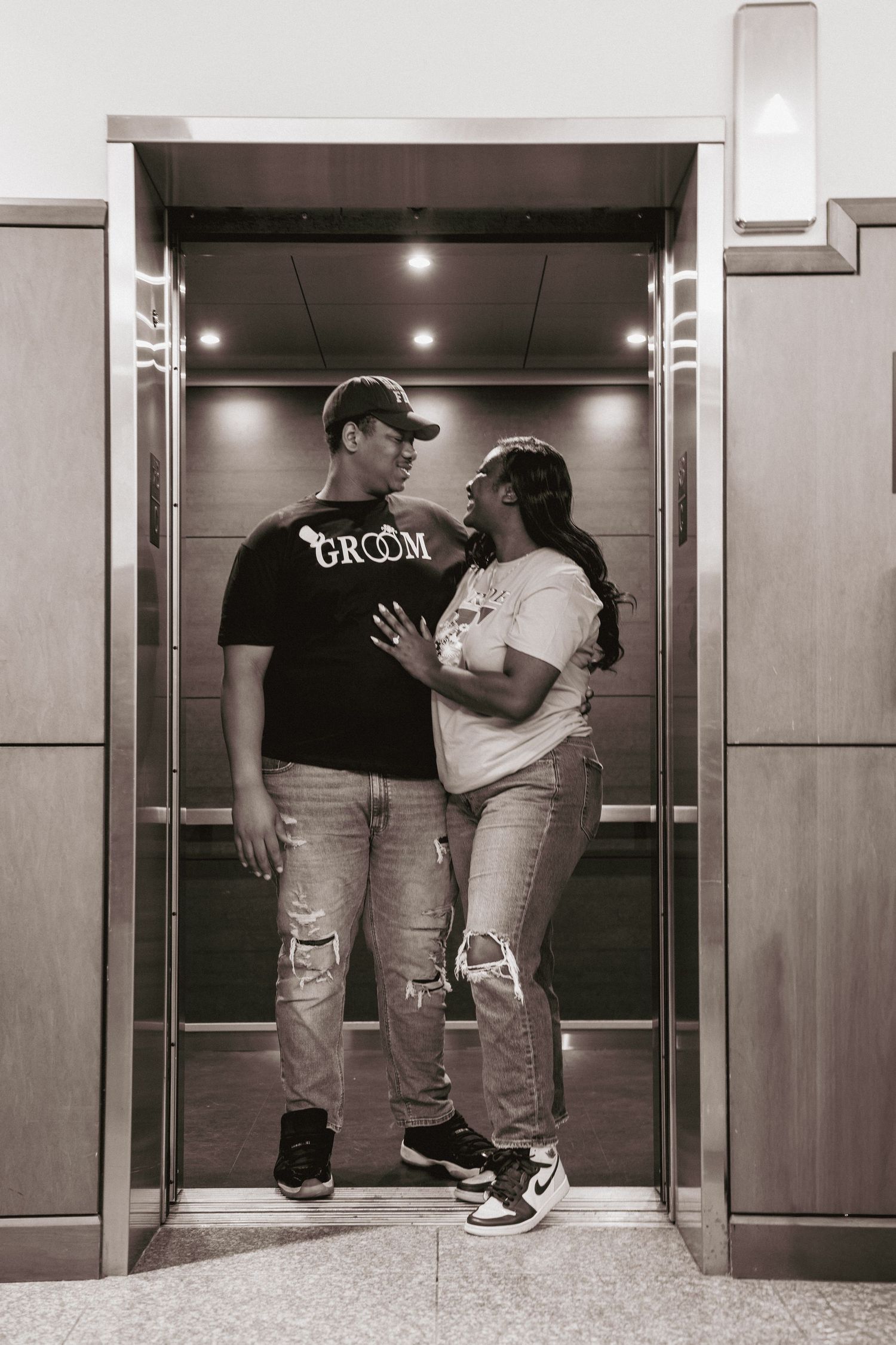 A romantic elevator photoshoot sequence showing a couple in casual attire sharing intimate moments in black and white.