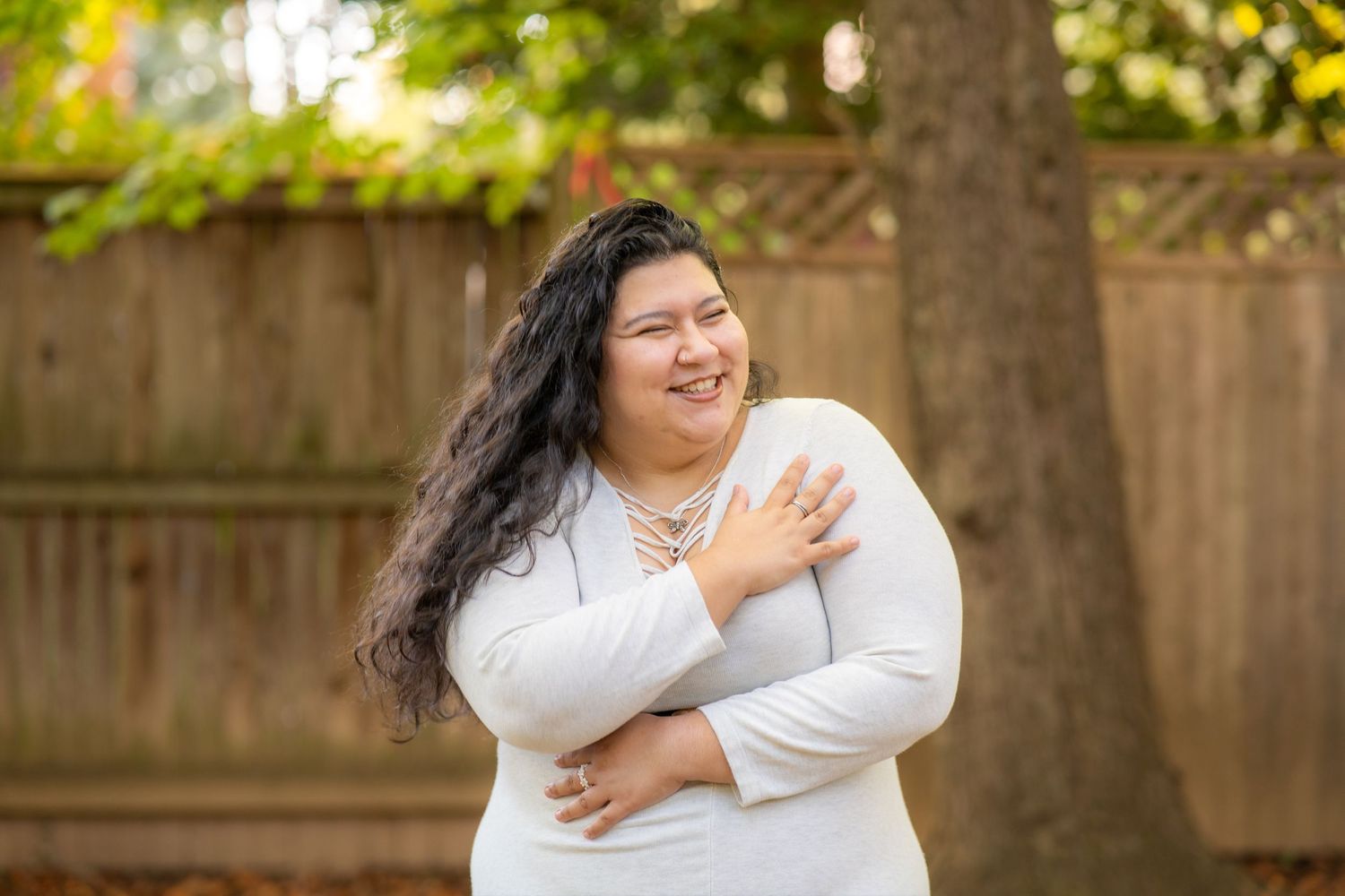 A couple in white clothing shares joyful moments together during an outdoor photo session in a garden setting.