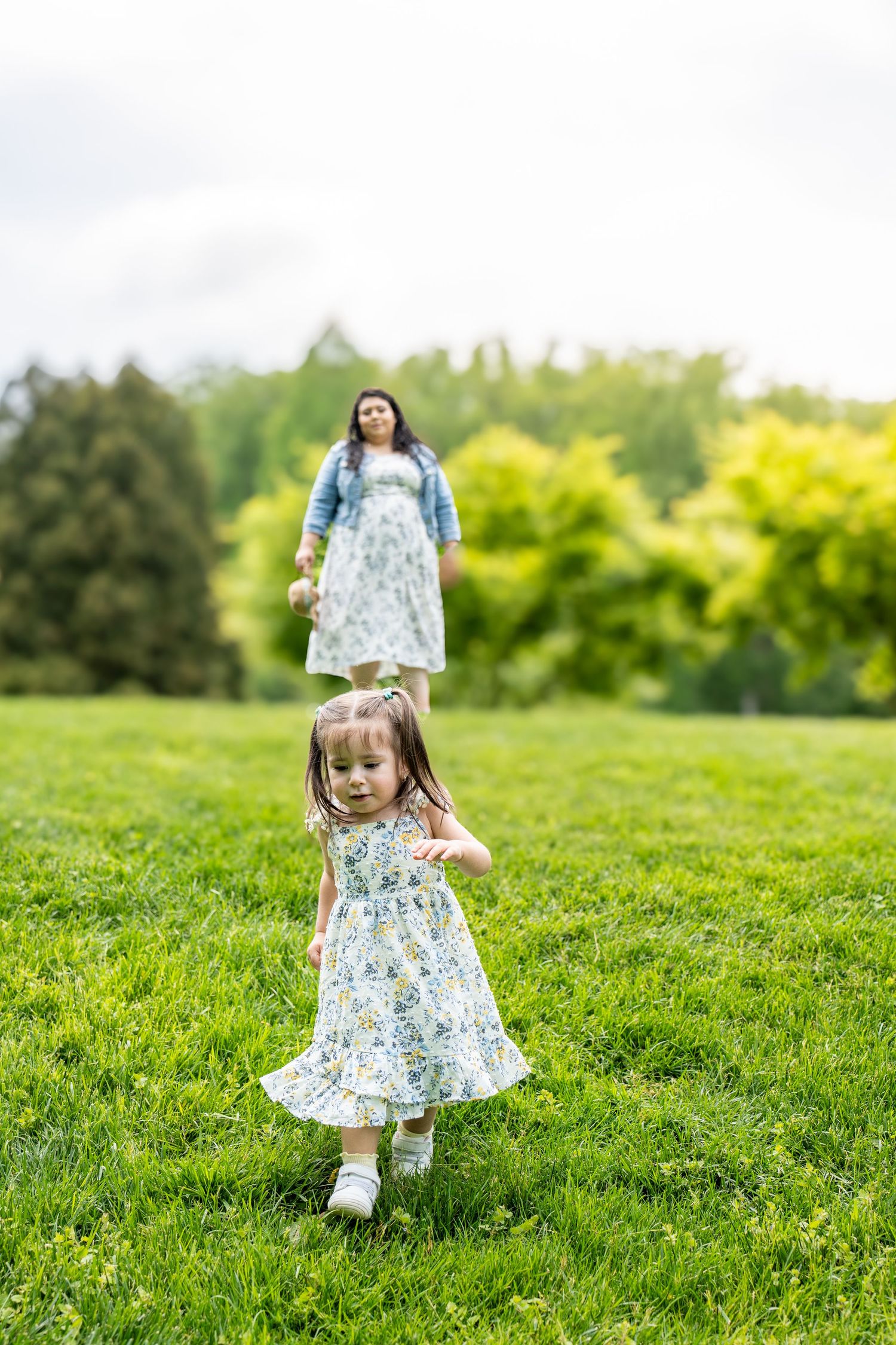Running and playing on lush green grass in a floral summer dress.