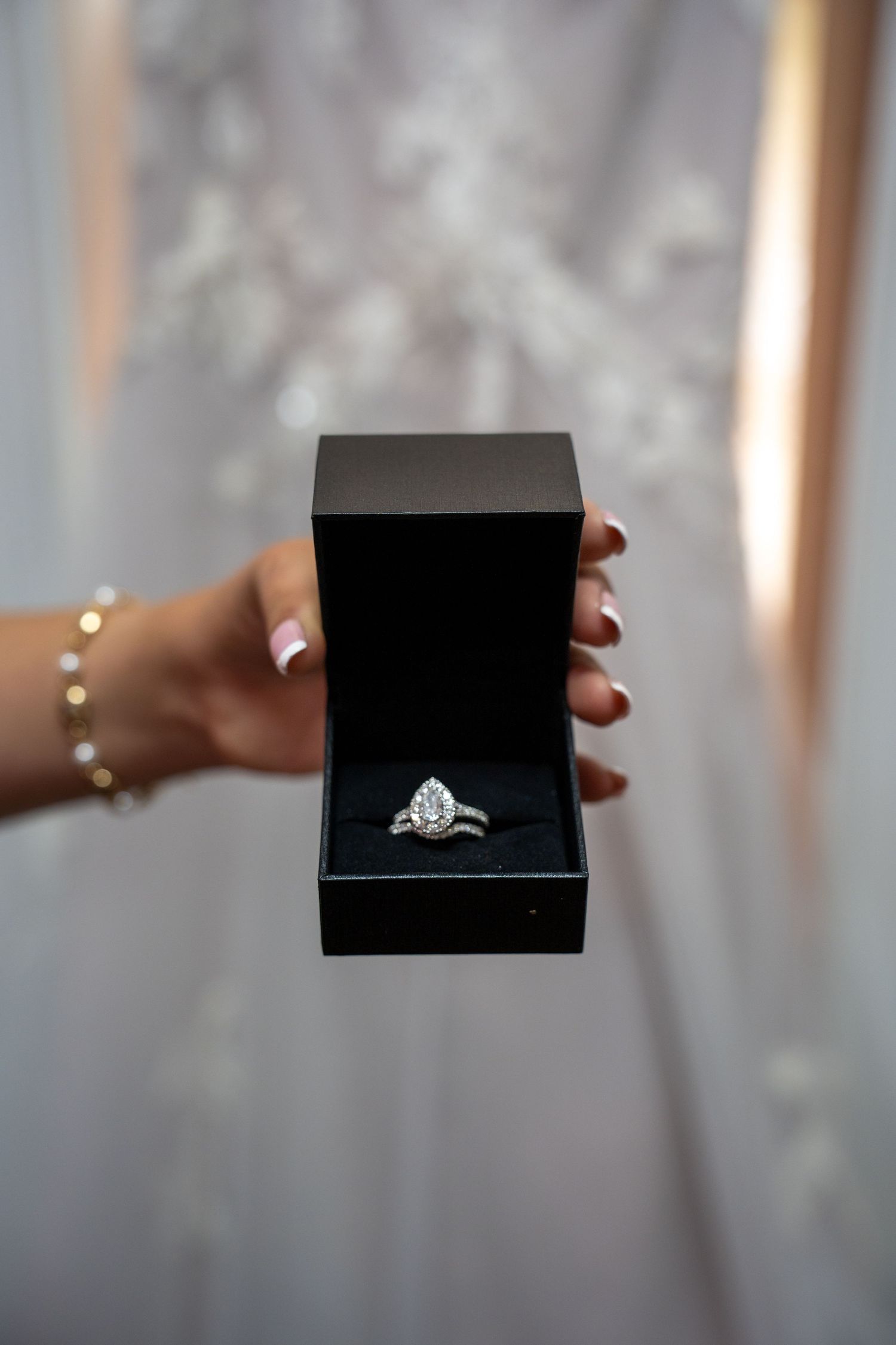 Four sequential photos showing hands holding a black ring box displaying a sparkling diamond engagement ring.