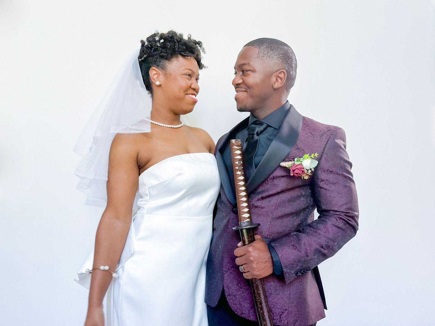 Wedding couple in formal attire with white dress and purple suit.