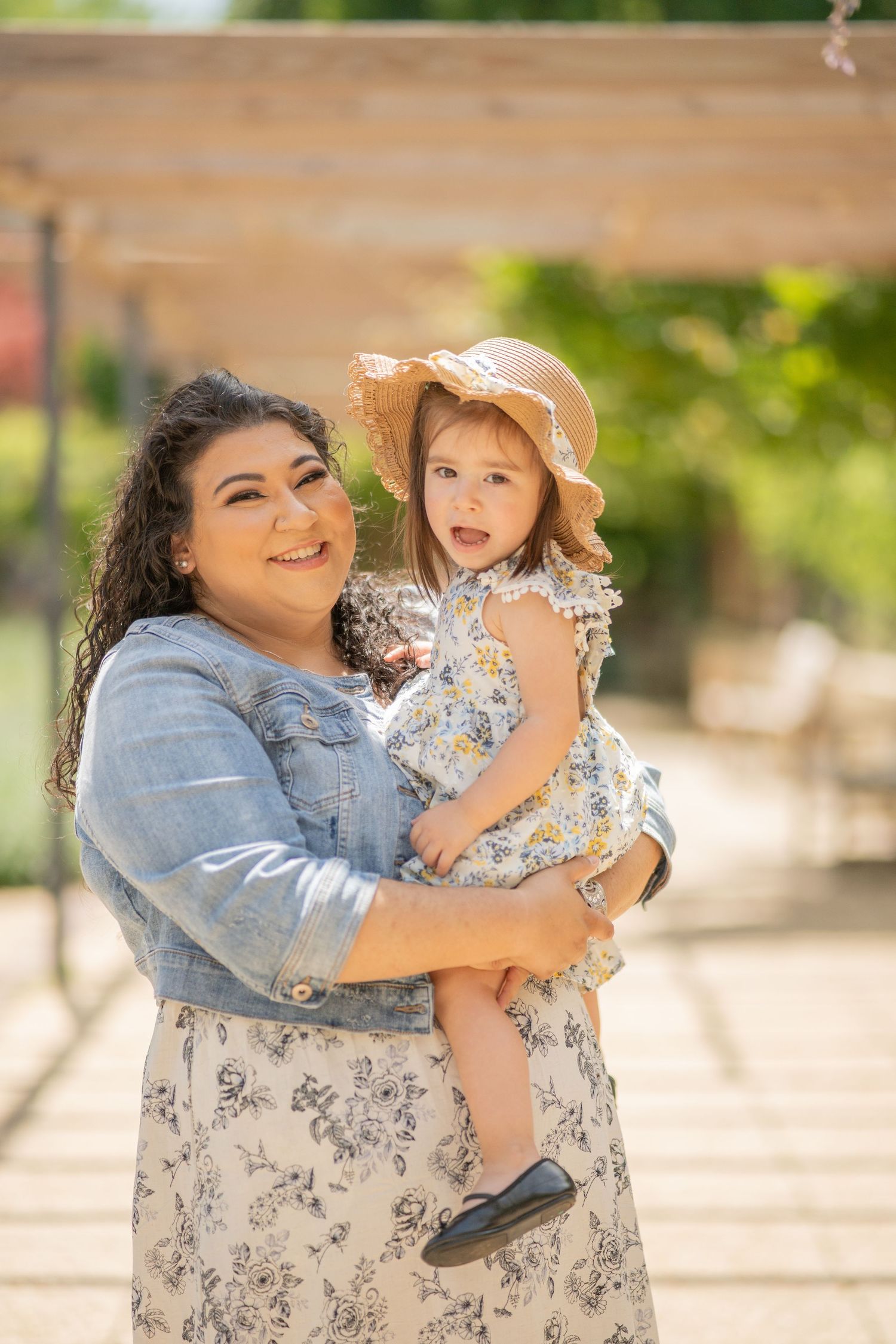 Mother and daughter sharing happy moment outdoors in summer attire.