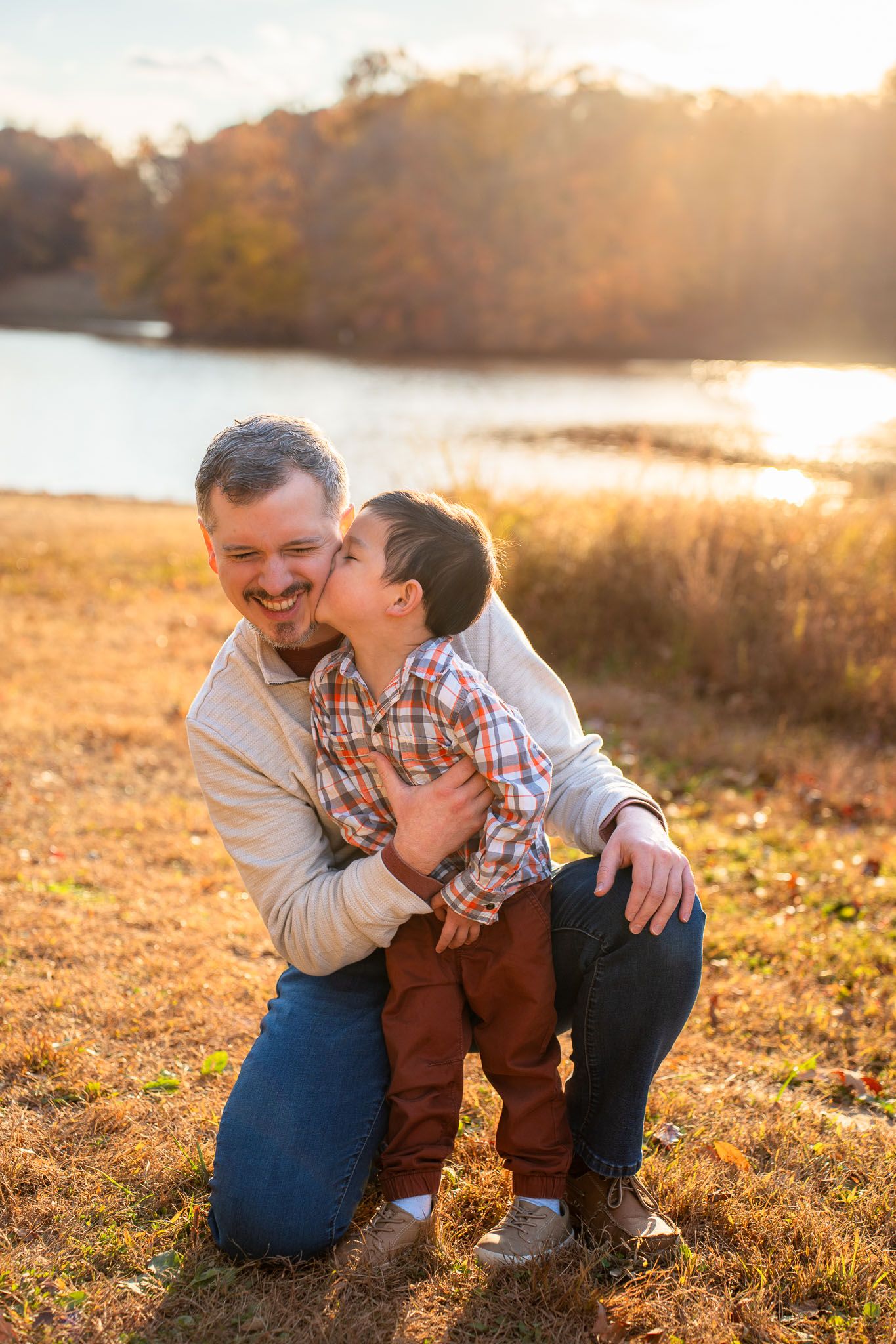 A touching moment between two people sharing a warm embrace in a sunlit field at golden hour.