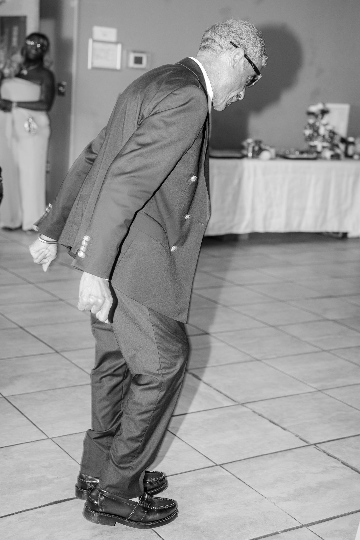 Wedding Bride's Father in Black and white photo dancing on a tiled floor at a his daughters wedding.
