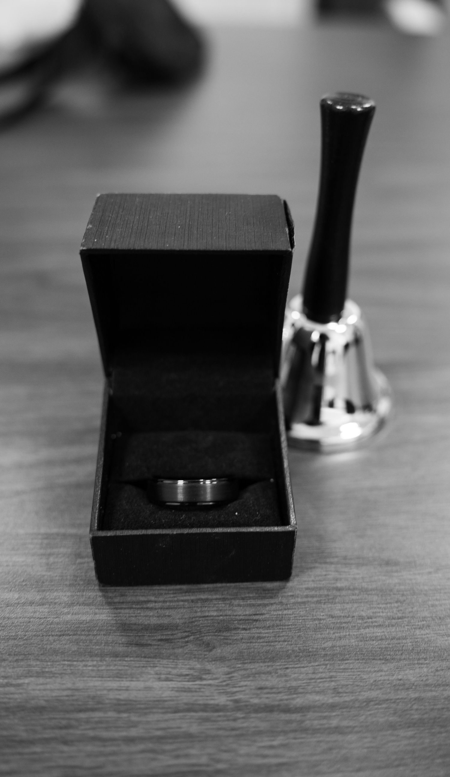 Black ring box opening sequence showing engagement ring on wooden surface.
