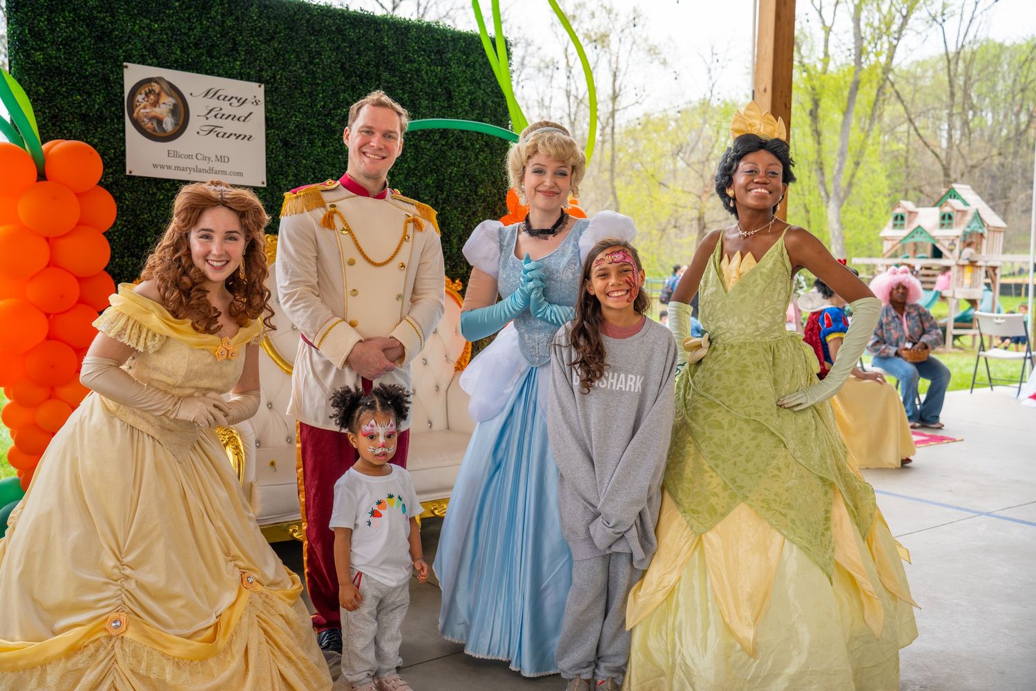 People dressed as fairy tale characters posing together at an outdoor event.