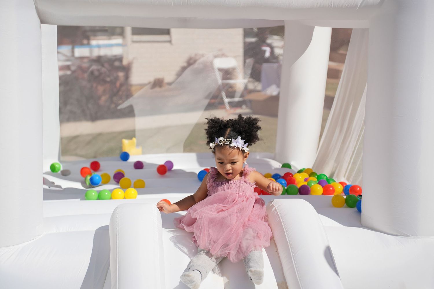 A bright indoor photo session setup with white walls and colorful decorative elements.