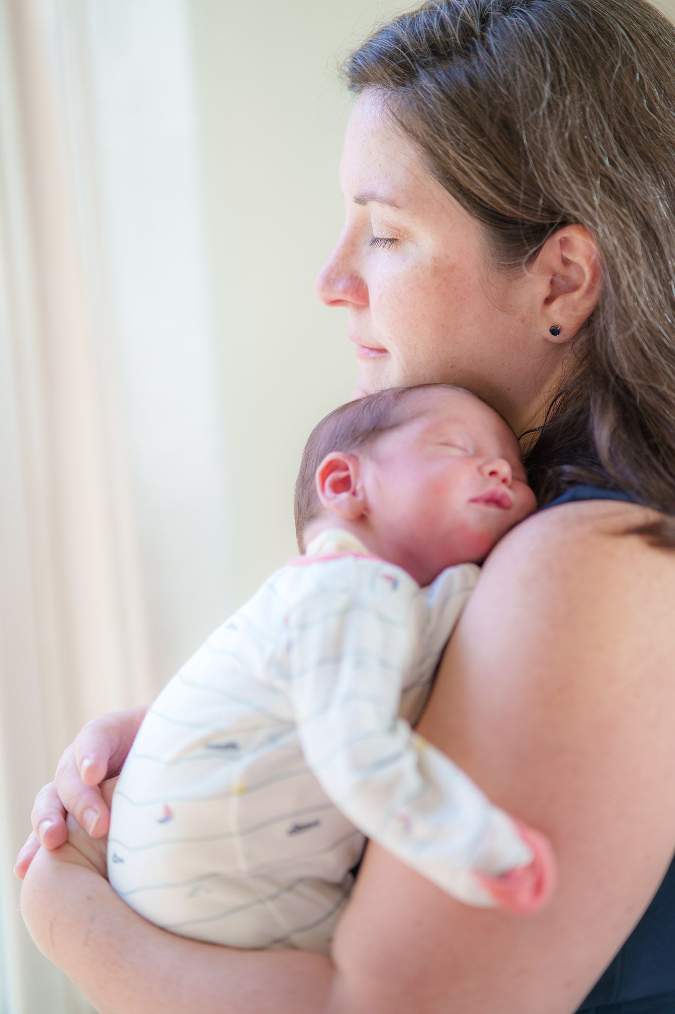 A series of tender moments showing a parent cradling and bonding with their newborn baby in white clothing.