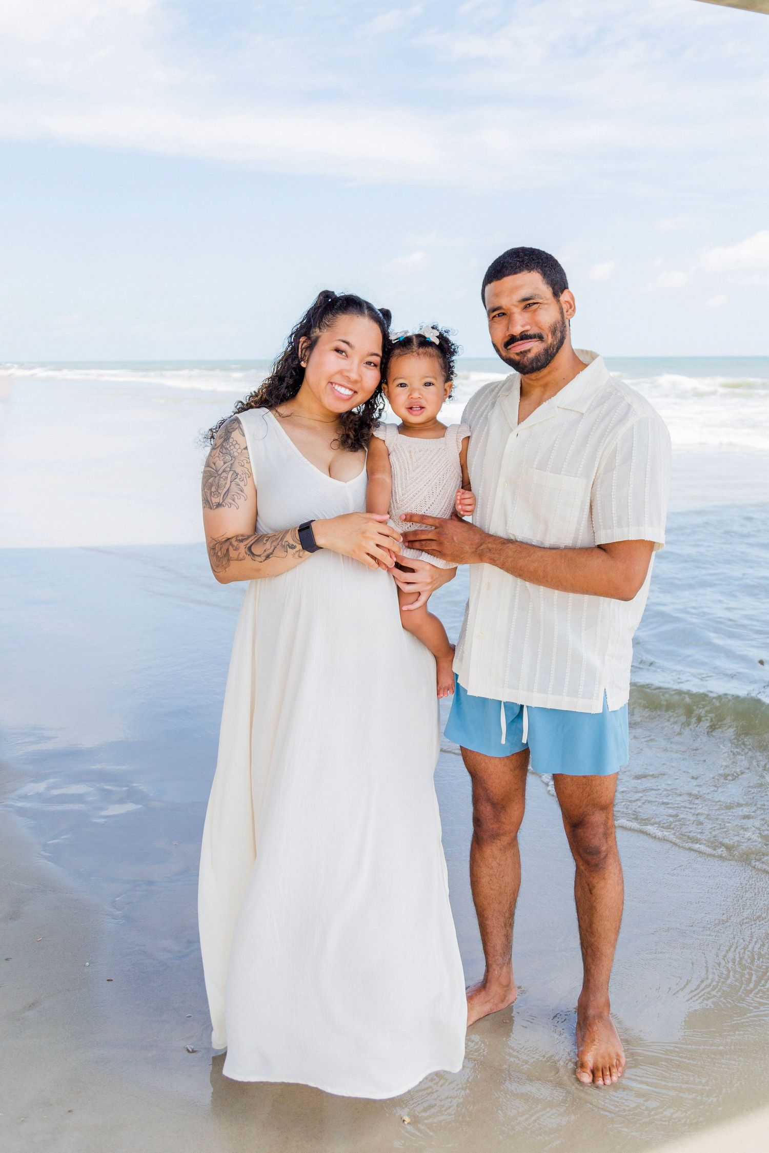 Family portrait session at the beach with ocean waves in background.