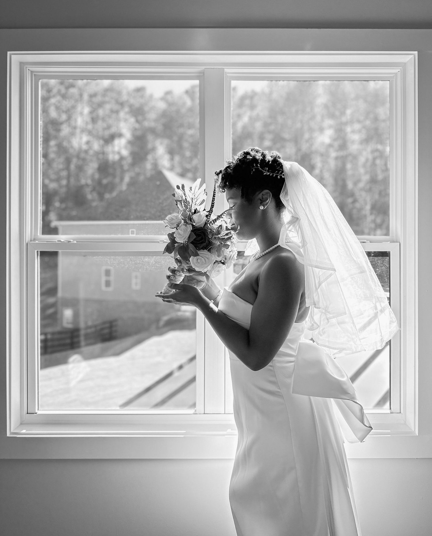 Black and white wedding photography with window light and bridal veil.