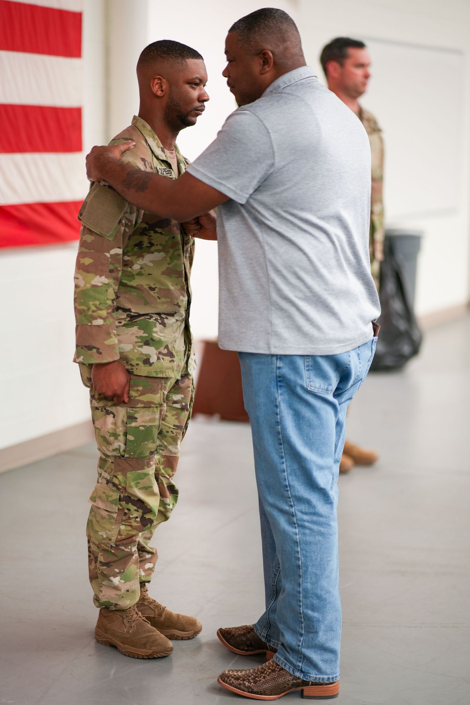 A series of photos showing a uniformed service member and civilian having an emotional reunion against an American flag backdrop.