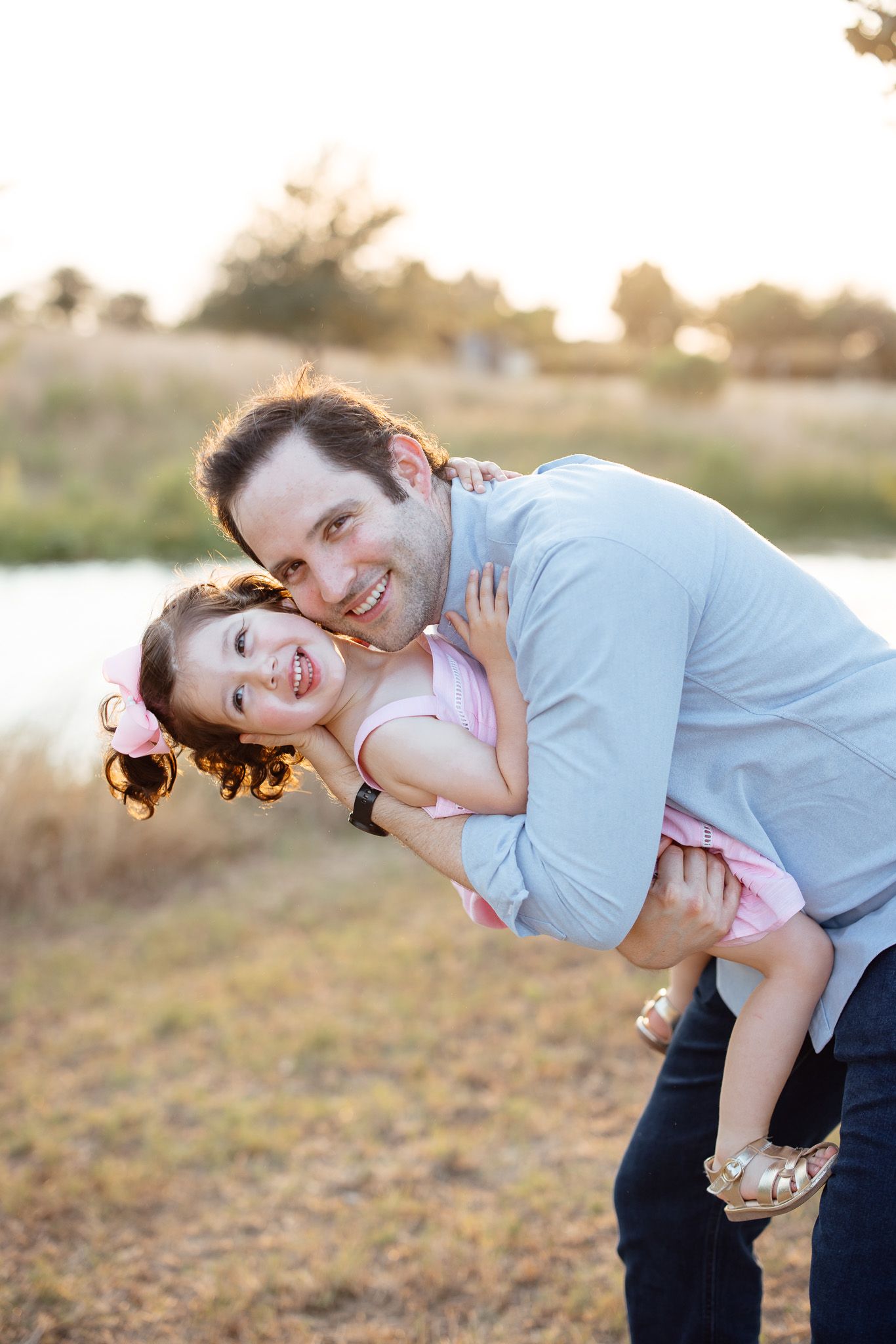 A couple poses affectionately in a sunset-lit field creating a romantic atmosphere during their photoshoot session.